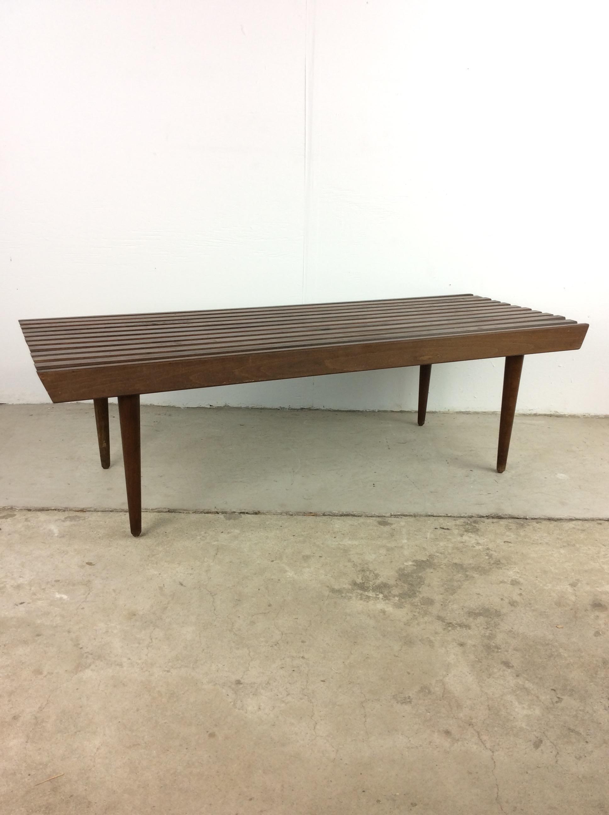 This mid century modern slat bench / coffee table in the style of Adrian Pearsall for Craft Associates features hardwood construction, original walnut finish, and tall tapered legs. 

Matching slat end table available separately. Complimentary