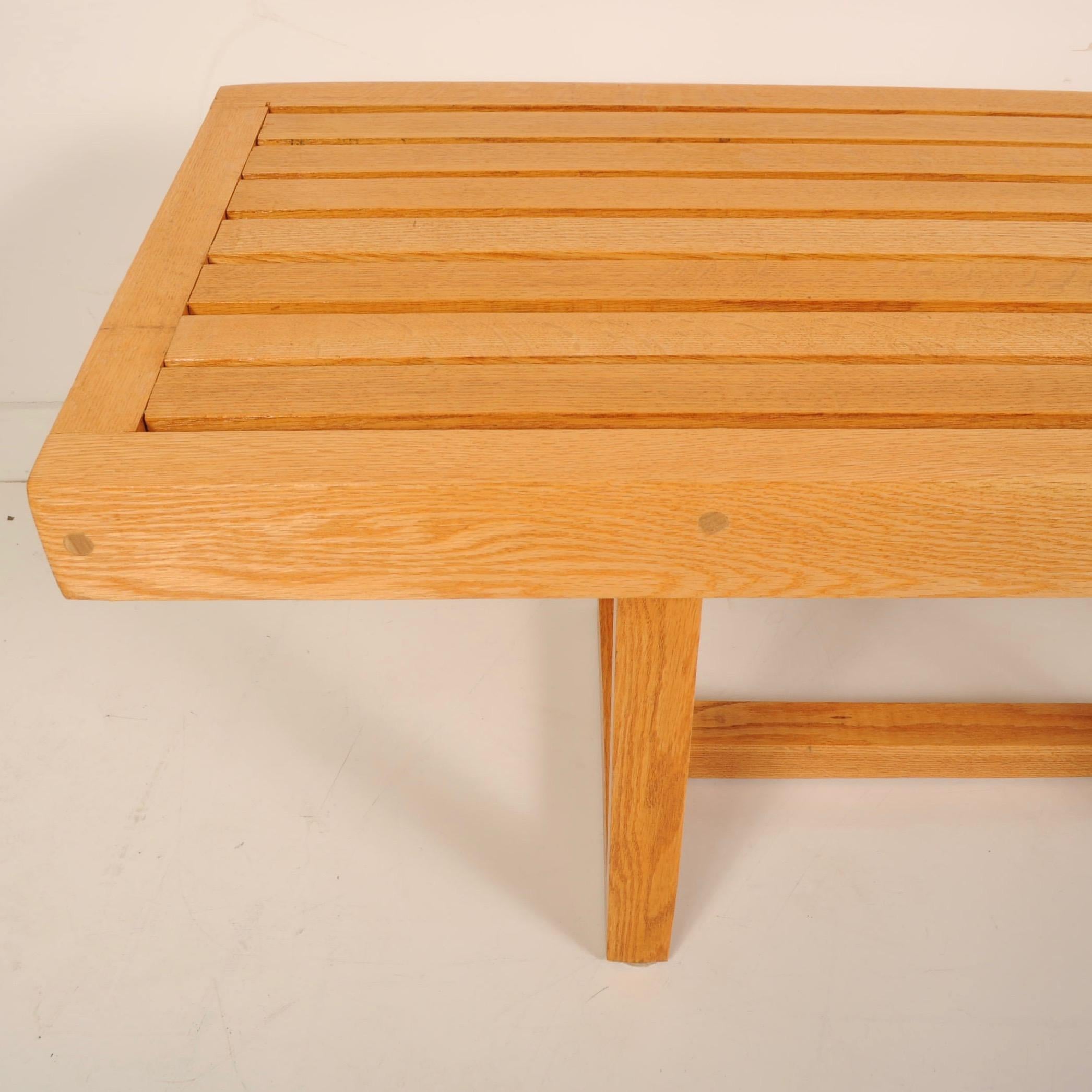 Craftsman-made solid oak bench in the manner of George Nelson, made with wooden pegs instead of glue and screws. Can be used as a bench or coffee table.