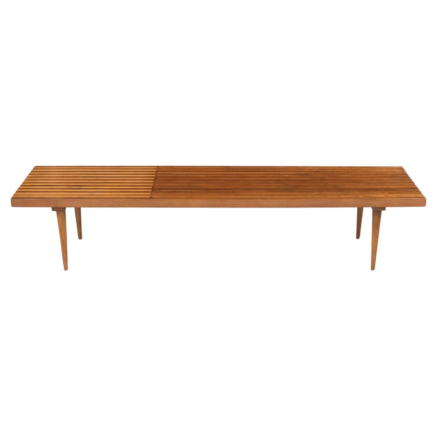 Introducing our masterfully restored Mid-Century Modern slatted bench, a symbol of exceptional craftsmanship in solid maple and walnut wood. The design exudes elegance with its clean, sleek lines, which have been brought to life with a fresh natural