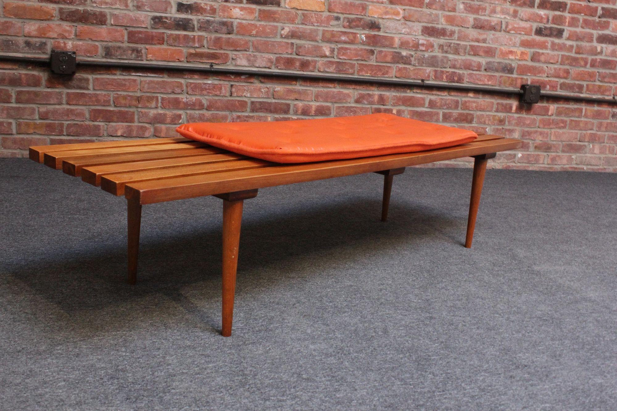 Classic Mid-Century American Modern slatted oak bench or coffee table supported by four, slim, tapered legs (ca. 1950s, USA).
Includes a removable orange vinyl cushion
Conservatively refinished condition but light wear remains (minor