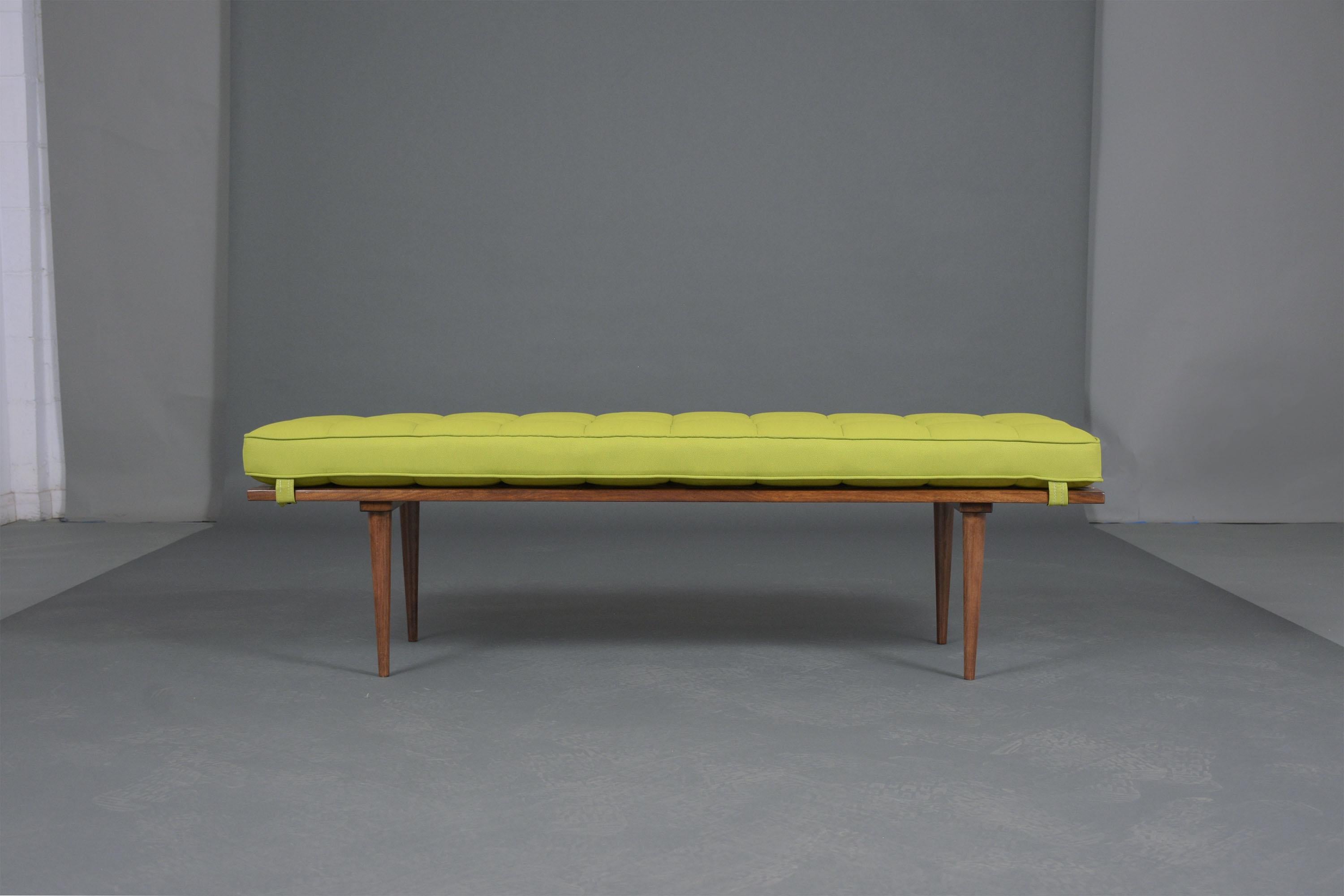 An extraordinary mid-century slatted bench crafted out of wood new stained a walnut color with lacquered finished and professionally restored by our expert craftsmen. This piece features a new 2.5