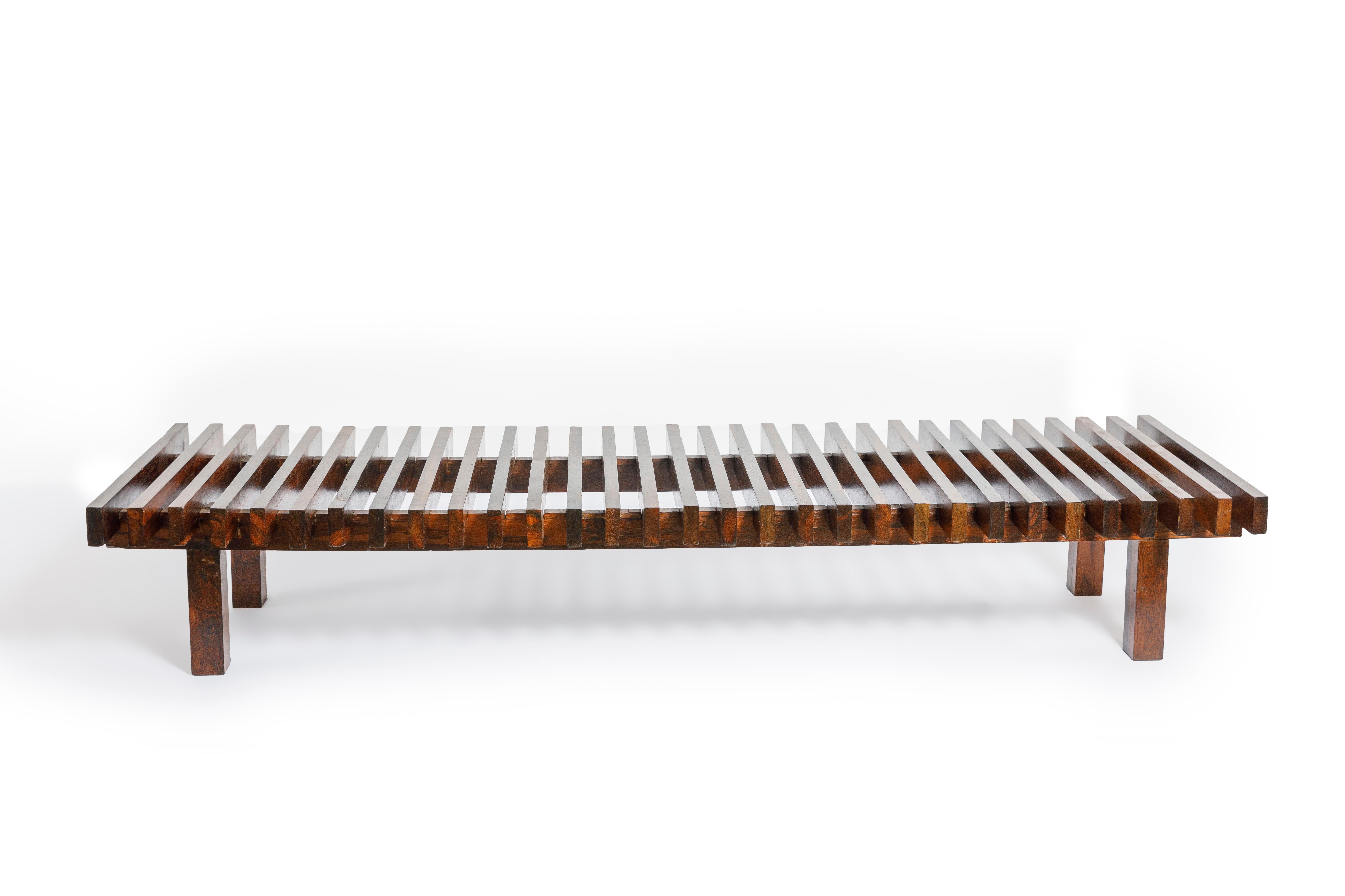 Slatted bench produced in Brazil in the 1970s by Forma Manufacture. 
This beautiful piece's seating is composed of regularly arranged solid Brazilian hardwood slats, finished with natural varnish maintaining the wood's character. 
The feet are