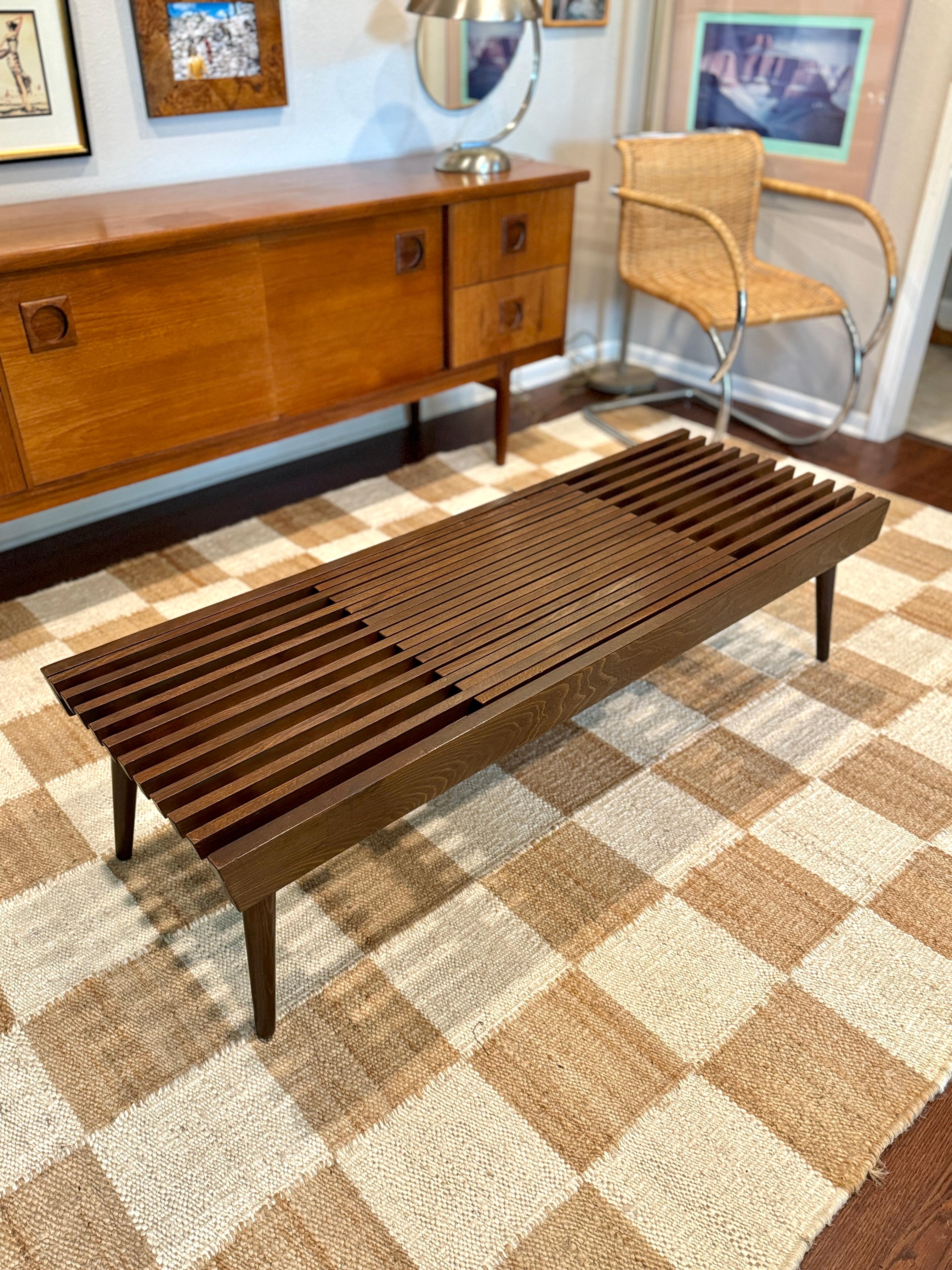Mid century modern slatted coffee table with extending ends, circa 1960s. The table expands from 54” wide to 72”. Overall in very good condition with some cosmetic flaws that have been color corrected. Structurally sound and legs screw over for
