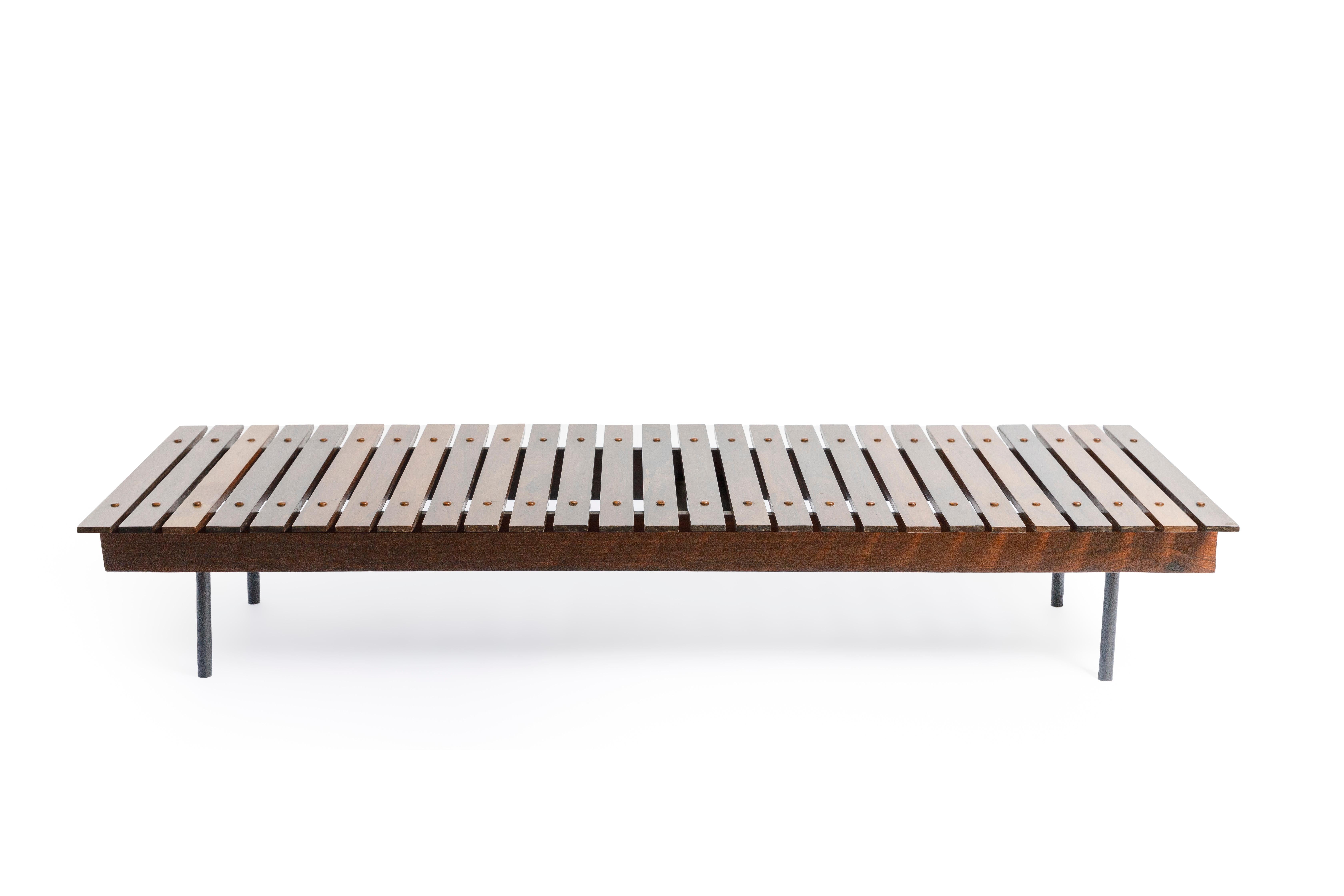 Slatted bench produced in Brazil in the 1950s by OCA manufacture. This beautiful piece's seating is composed of regularly arranged solid Brazilian hardwood slats, finished with natural varnish maintaining the wood's character, over four feet in