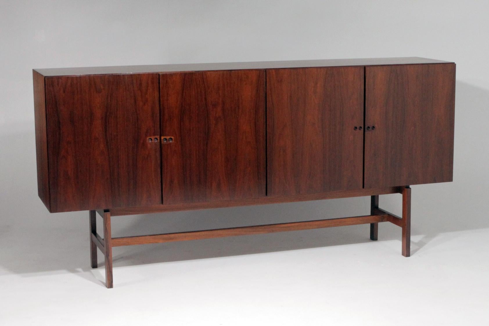 An incredibly well made rosewood credenza by an unknown Danish maker. Book matched rosewood top, sides and doors, inside and out, and the detail on the inside of the doors is as impressive as on the outside. Brass hinges, felt lined drawers,