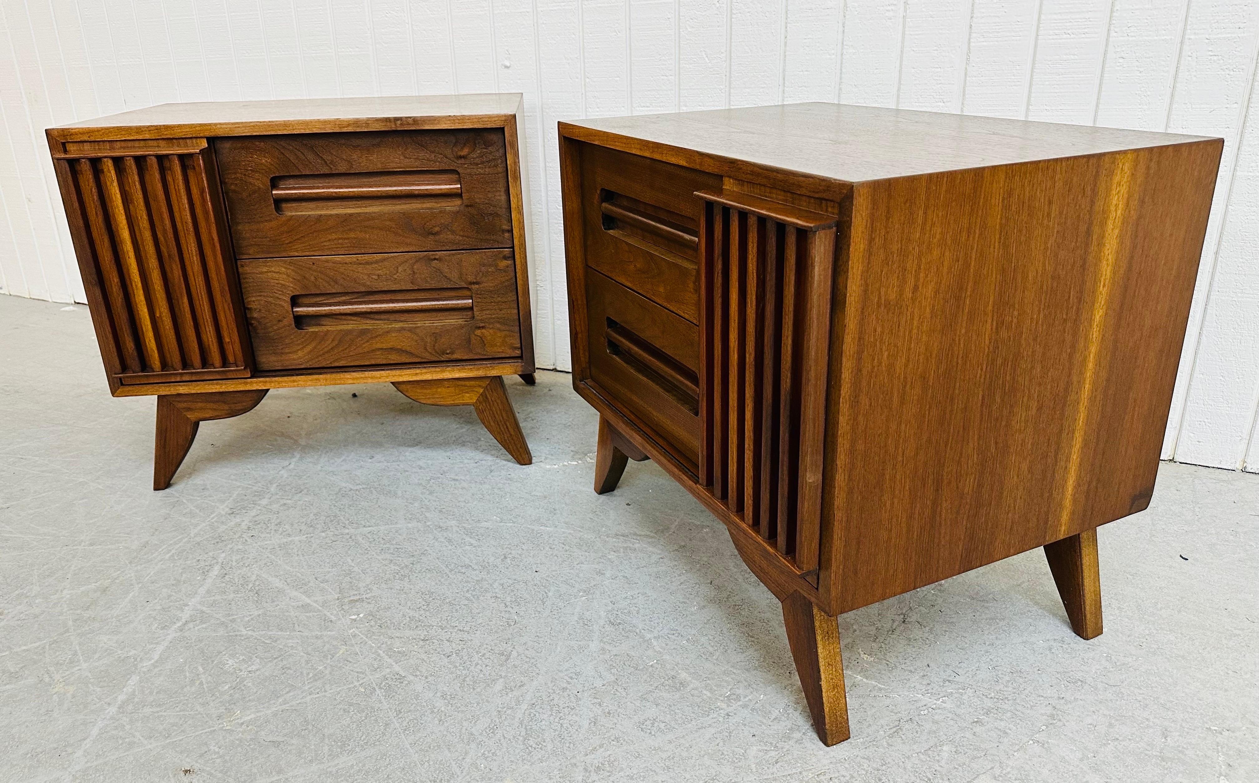 This listing is for a pair of Mid-Century Modern Sliding Door Walnut Nightstands. Featuring a straight line design, sliding door that reveals storage space, two drawers, flared modern legs, and a beautiful walnut finish. This is an exceptional