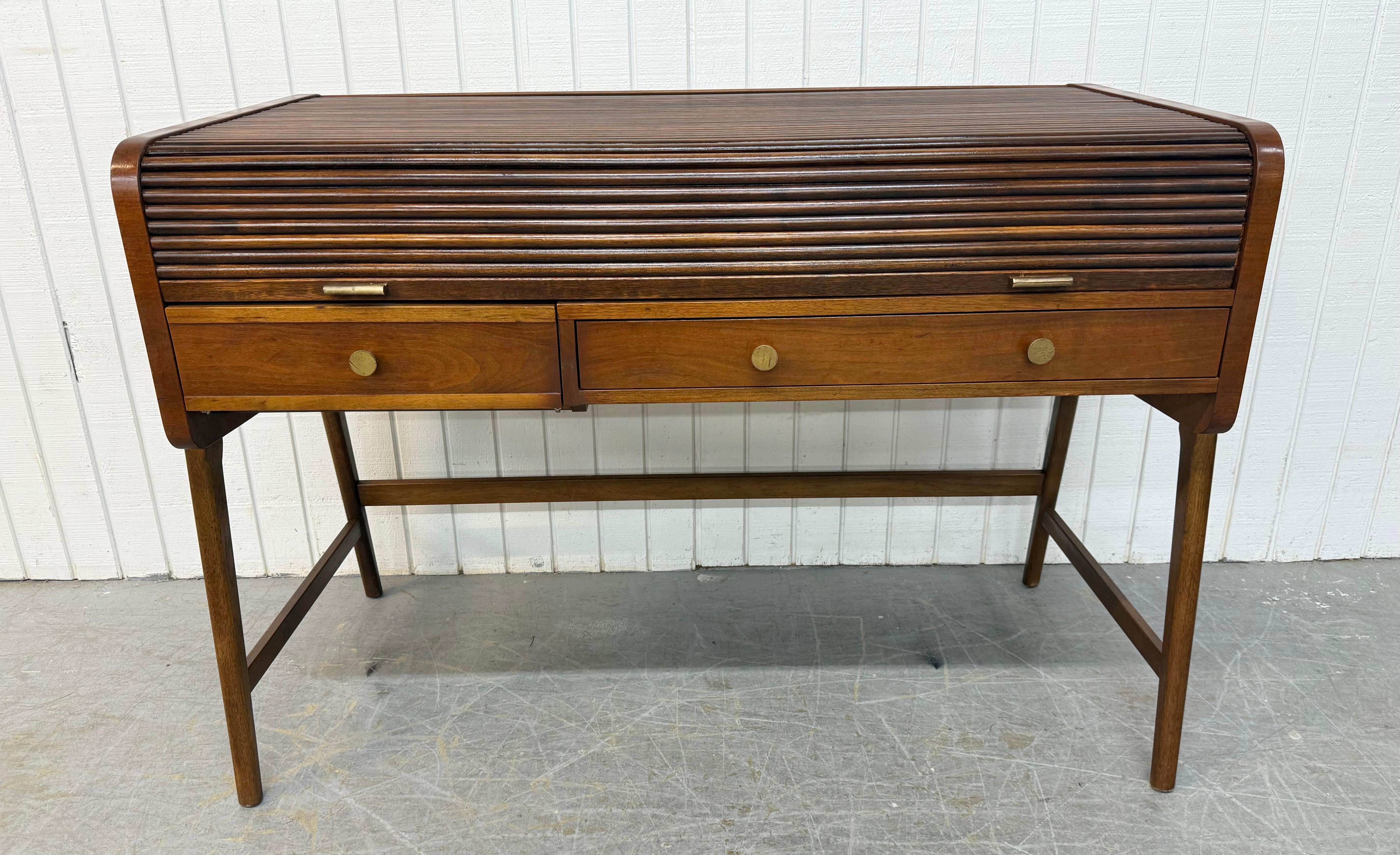 This listing is for a Mid-Century Modern Sligh-Lowry Floating Roll-Top Walnut Desk. Featuring modern outside legs that give the center of the desk a floating appearance, a roll-top design that opens up to a large writing area, two drawers that open