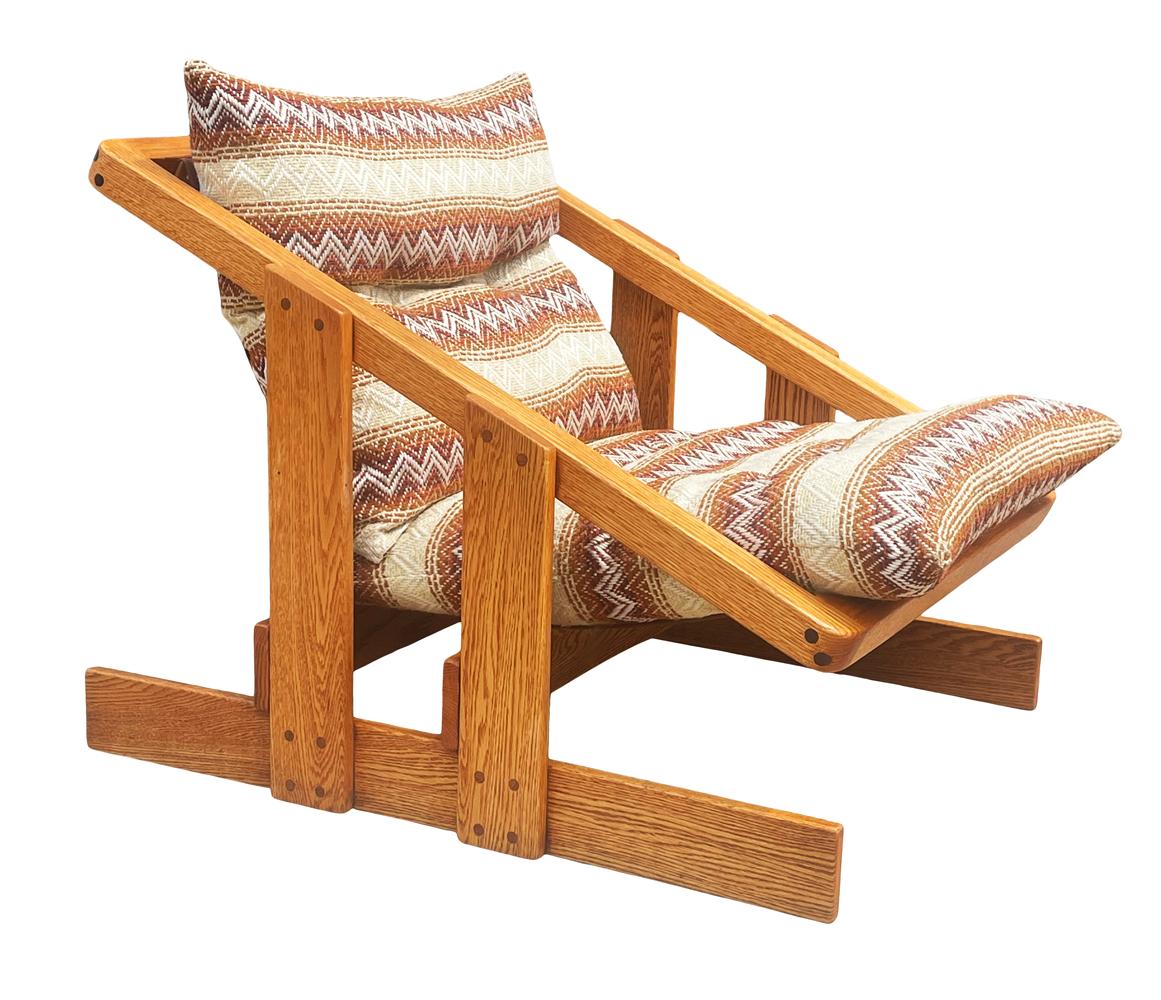A funky sling chair designed by Lou Hodges circa 1970's. It features solid oak framing with a wool tweed cushion. Fabric is original and usable.
