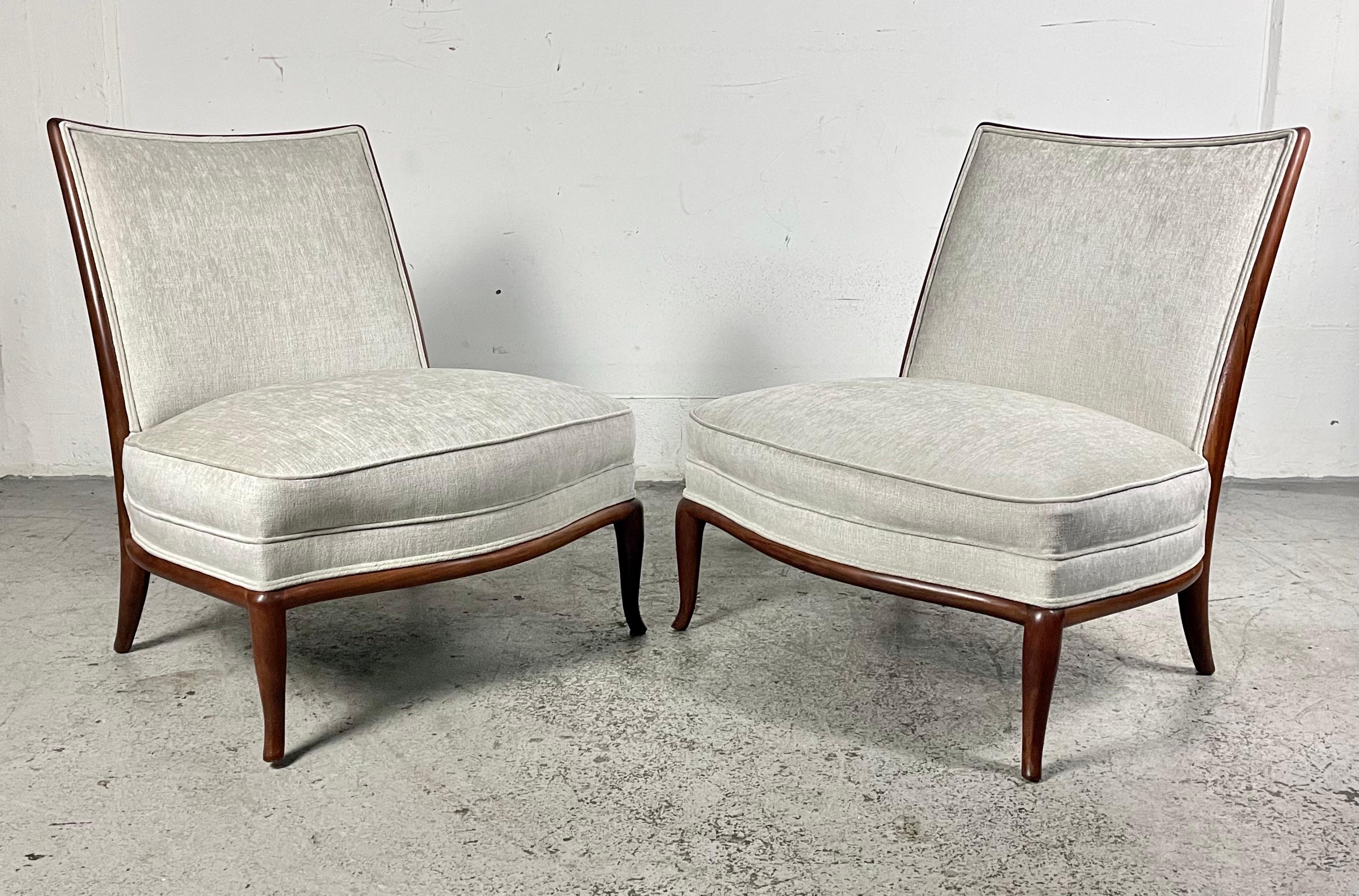 A fabulous and timeless pair of slipper chairs by T.H. Robsjohn-Gibbings for Widdicomb. The graceful curvy lines complement these scaled up accent chairs. Tastefully reupholstered in Knoll Summit fabric in a neutral alabaster white color and soft