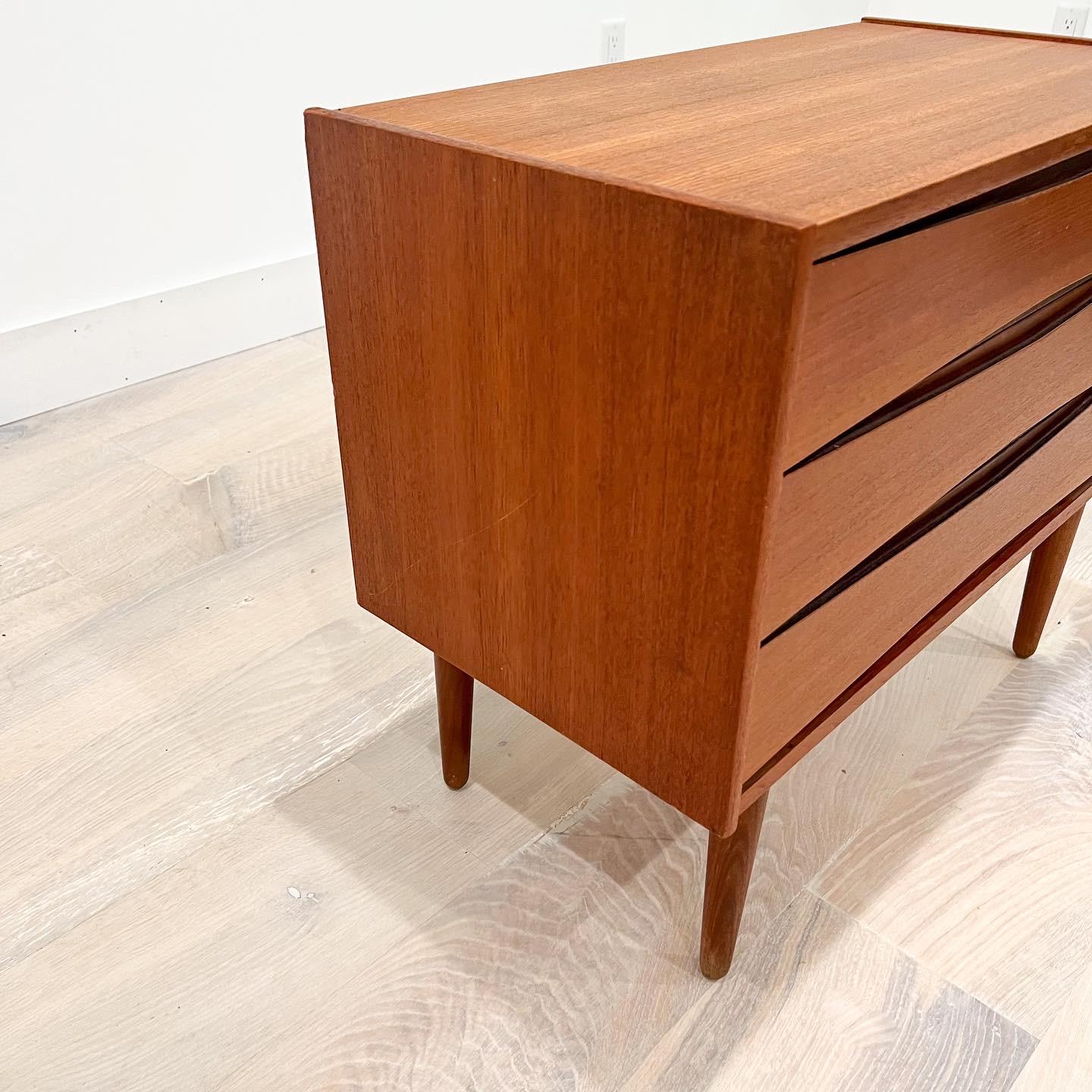Mid-Century Modern teak 3 drawer dresser with sculpted drawer pulls. We believe it to be Kaiser of Norway. The top has been sanded and restored. Some light scuffing/scratching from age appropriate wear.