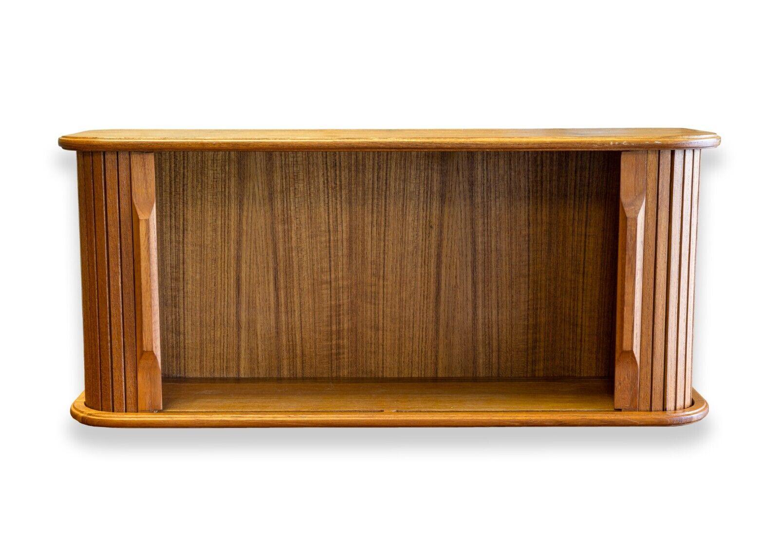 A mid century modern small Danish teak wood tambour door cabinet. A fantastic little storage container, great for any home or office desks. This piece features a full teak wood construction, lovely tambour doors that work flawlessly, and a fully