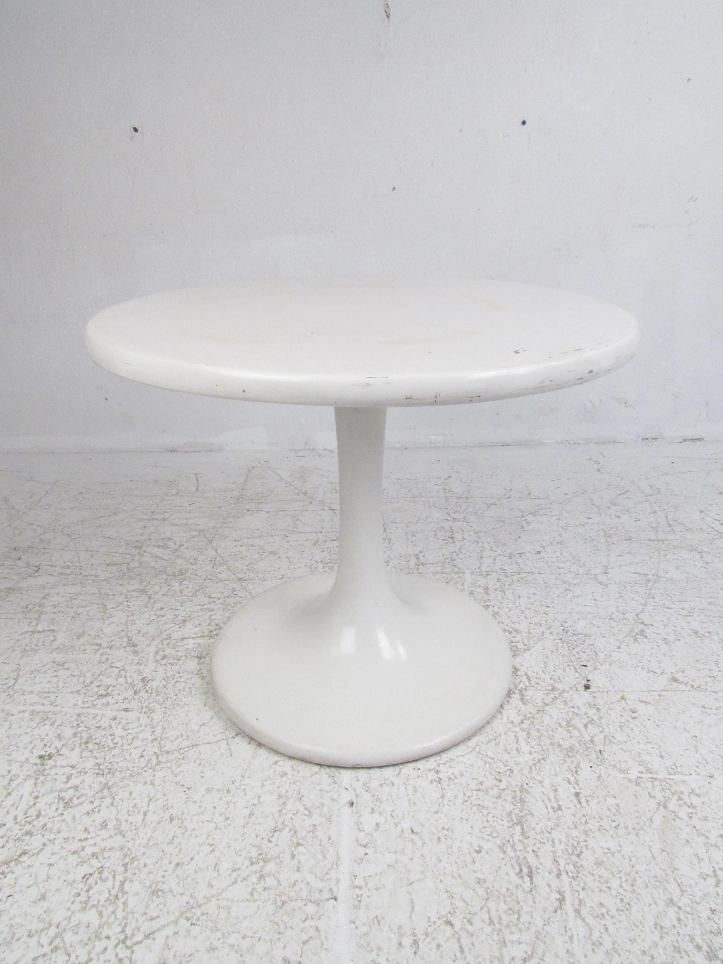 This stunning vintage modern dining set features child's size sculpted white chairs and a matching small table. A uniquely designed chair with a compartment made for additional storage underneath the seat. The gorgeous small white tulip shaped table