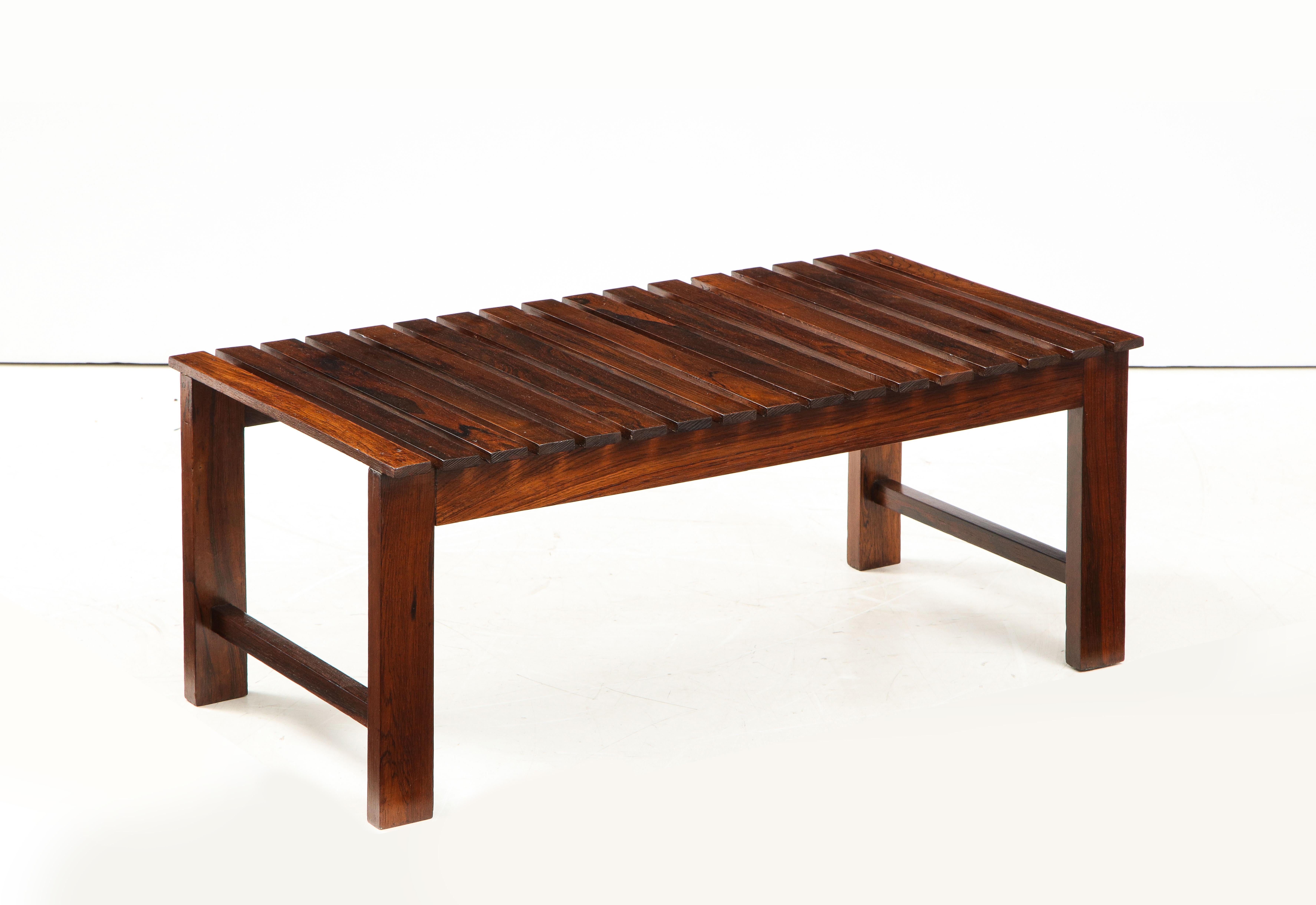 Small Mid-Century Modern slatted bench, Brazil, 1960s.

This Minimalist bench is structured in solid wood, completed with side stretchers for additional support, and featuring a seating composed of regularly arranged solid wood slats. Finished