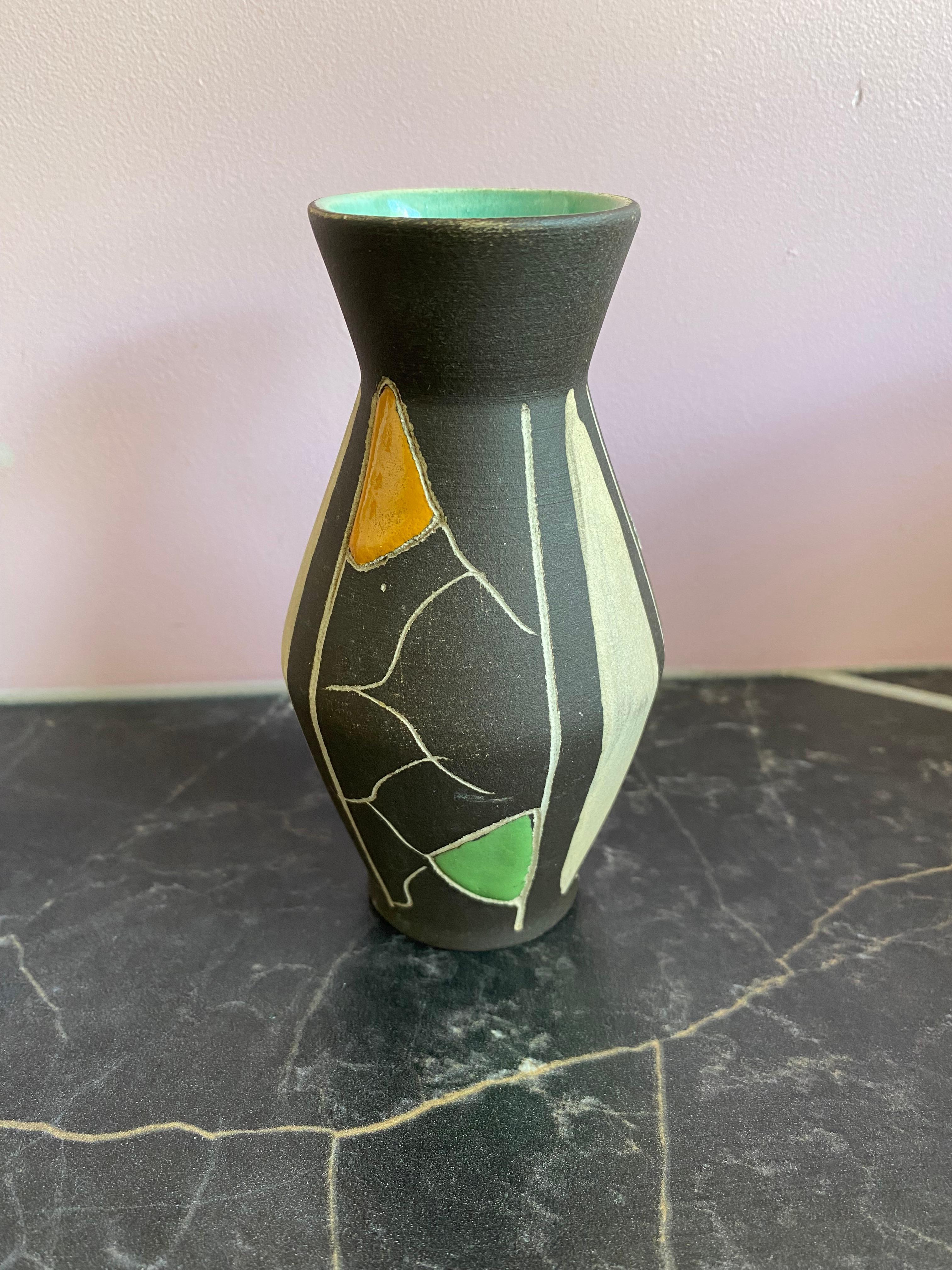 Eine atemberaubende und seltene kleine Vase von Bay Keramik, die von dem bekannten Designer Bodo Mans entworfen wurde.
BODO MANS wurde im Jahr 1935 geboren. Von 1949 bis 1951 machte er eine Lehre als Schaufensterdekorateur und Dekorationsmaler.
