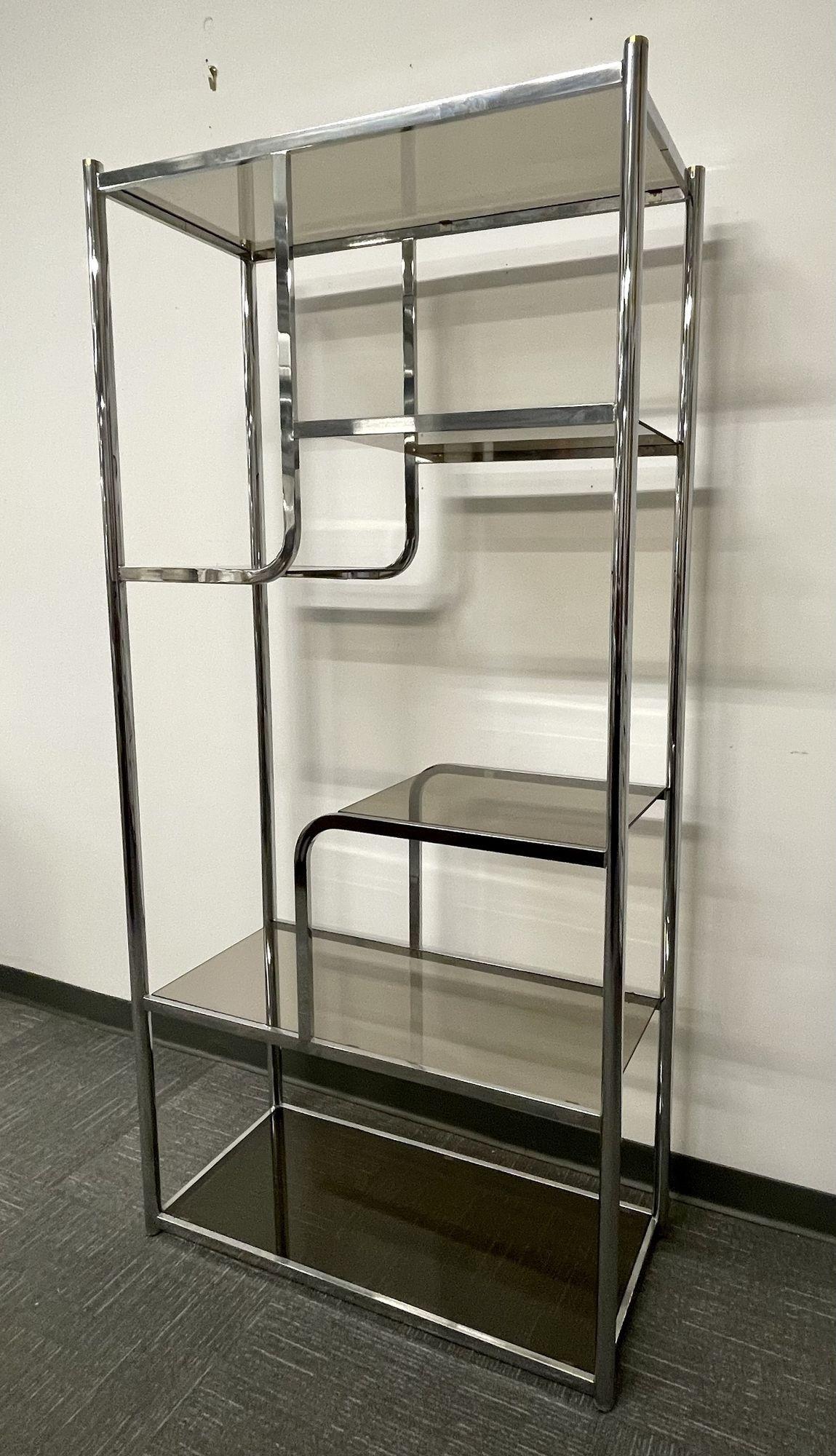 Mid-Century Modern smoke glass and chrome etagere, bookcase, wall unit.
 
A untiquely shaped chrome etagere or bookcase, wall unit having a chrome frame and smoked glass shelving.