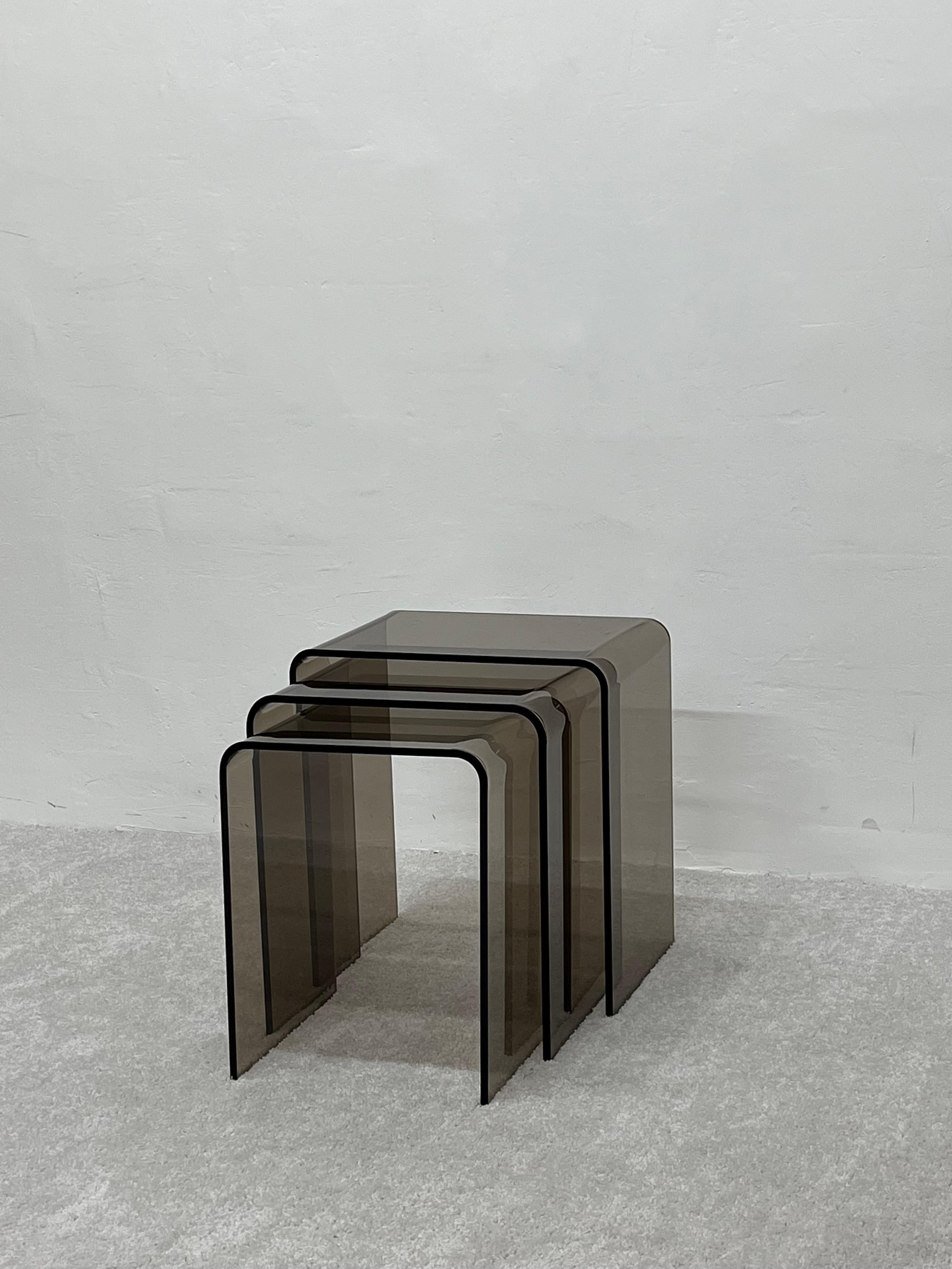 Set of three smoked brown lucite nesting tables from the 1960s.

Dimensions:
Large - W16-3/4