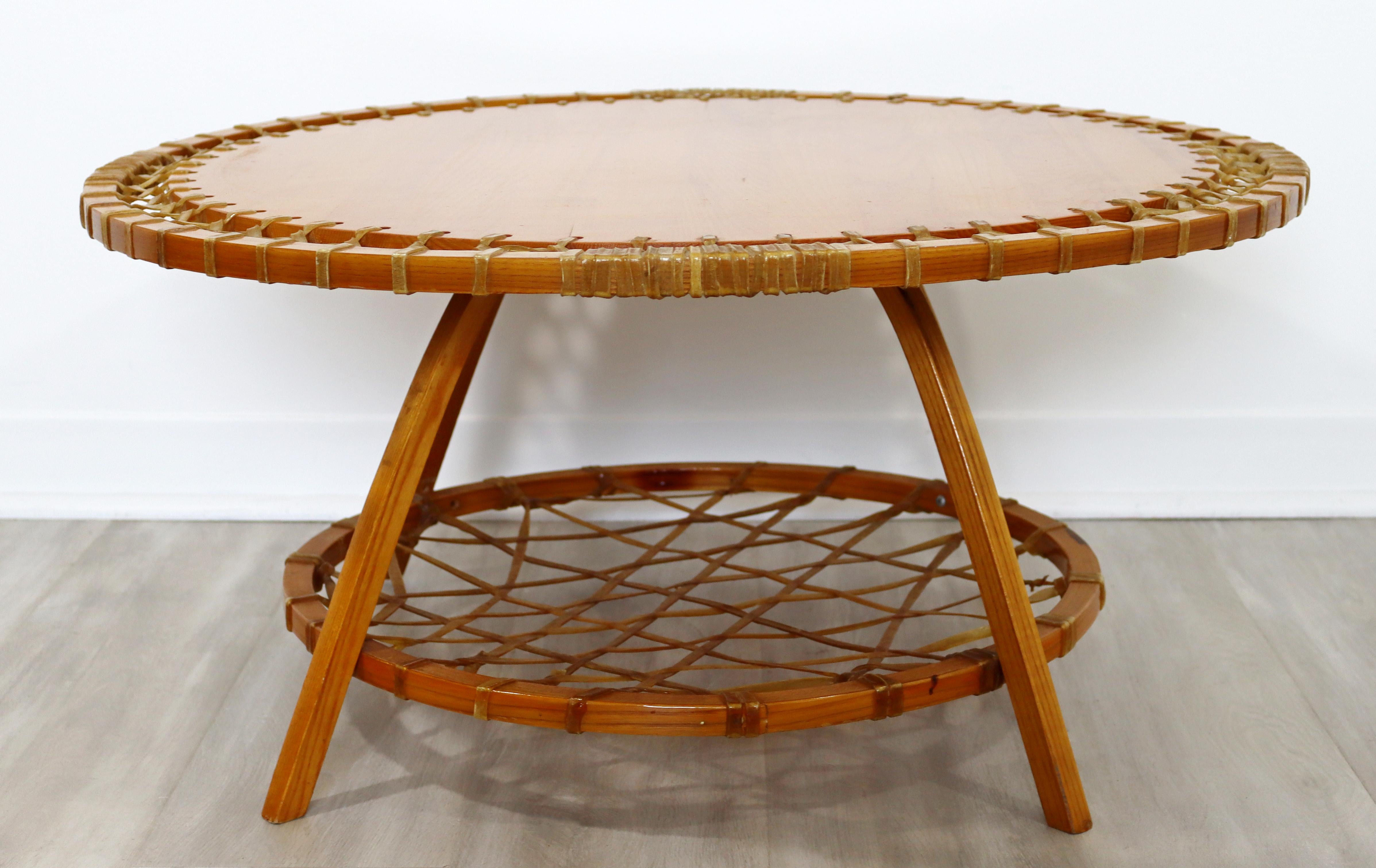 For your consideration is an outstanding, round, oak coffee table, with rawhide webbing like snow shoes, by Snocraft, circa the 1970s. In excellent vintage condition. The dimensions are 32