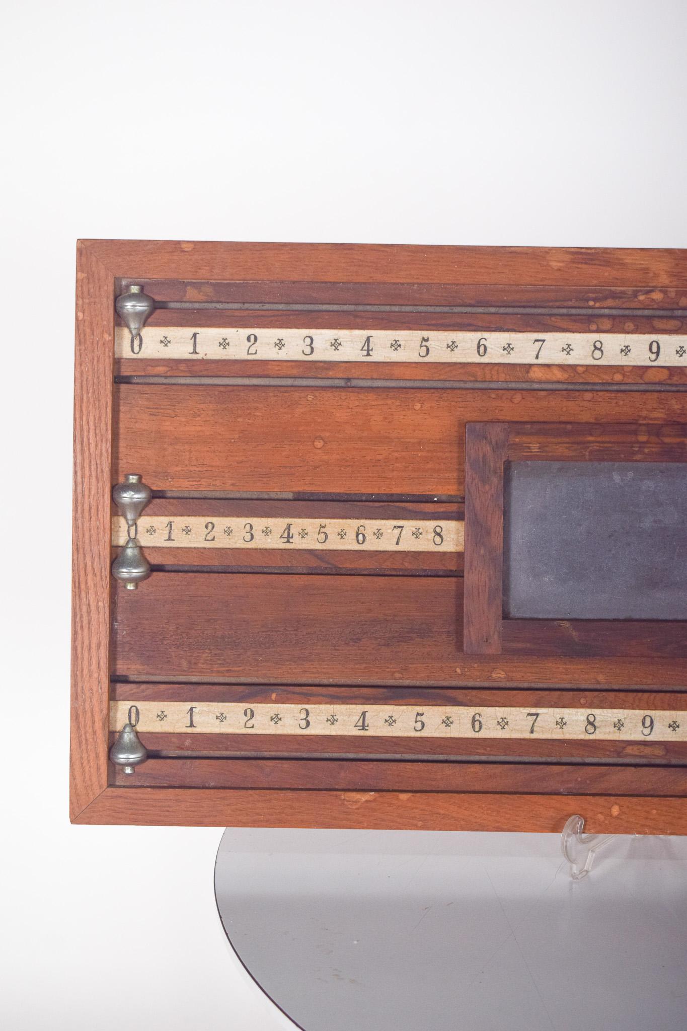 Snooker marker. Classic piece, made of dark wood, with vintage style details. It has three rulers numbered from 0 to 25, which allow you to monitor players' scores during the game. These rulers are accompanied by sliding metal pointers, which make