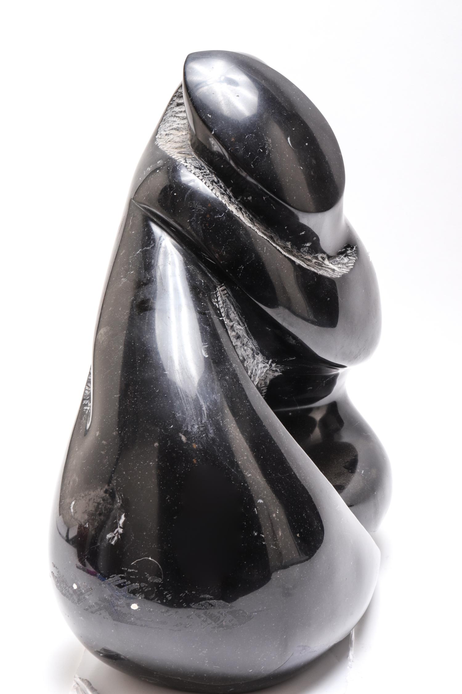 Mid-Century Modern soapstone sculpture depicting a stylized couple in embrace. The piece is in great vintage condition with age-appropriate wear and use. Measures: 17