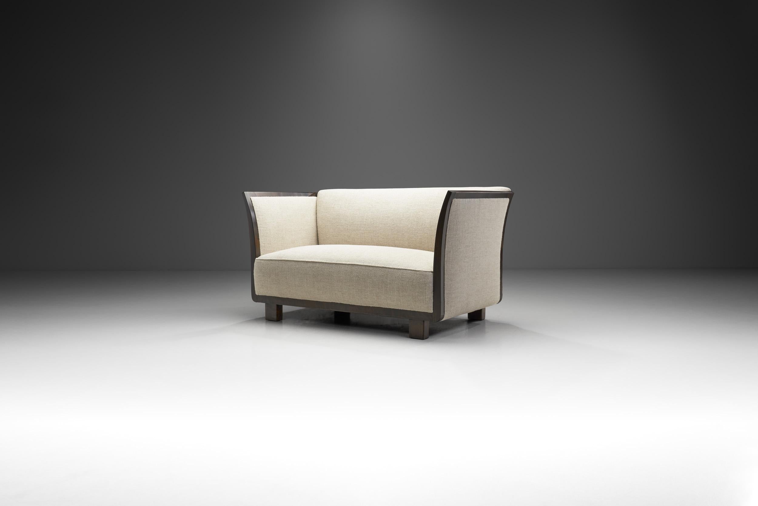 Dieses dänische Zweisitzer-Sofa hat eine elegante, moderne Note, die unverkennbar aus dieser Zeit stammt. Das Design zeichnet sich durch klare, scharfe Winkel und abgerundete Linien aus, die ein perfektes Gleichgewicht schaffen und zeigen, warum die