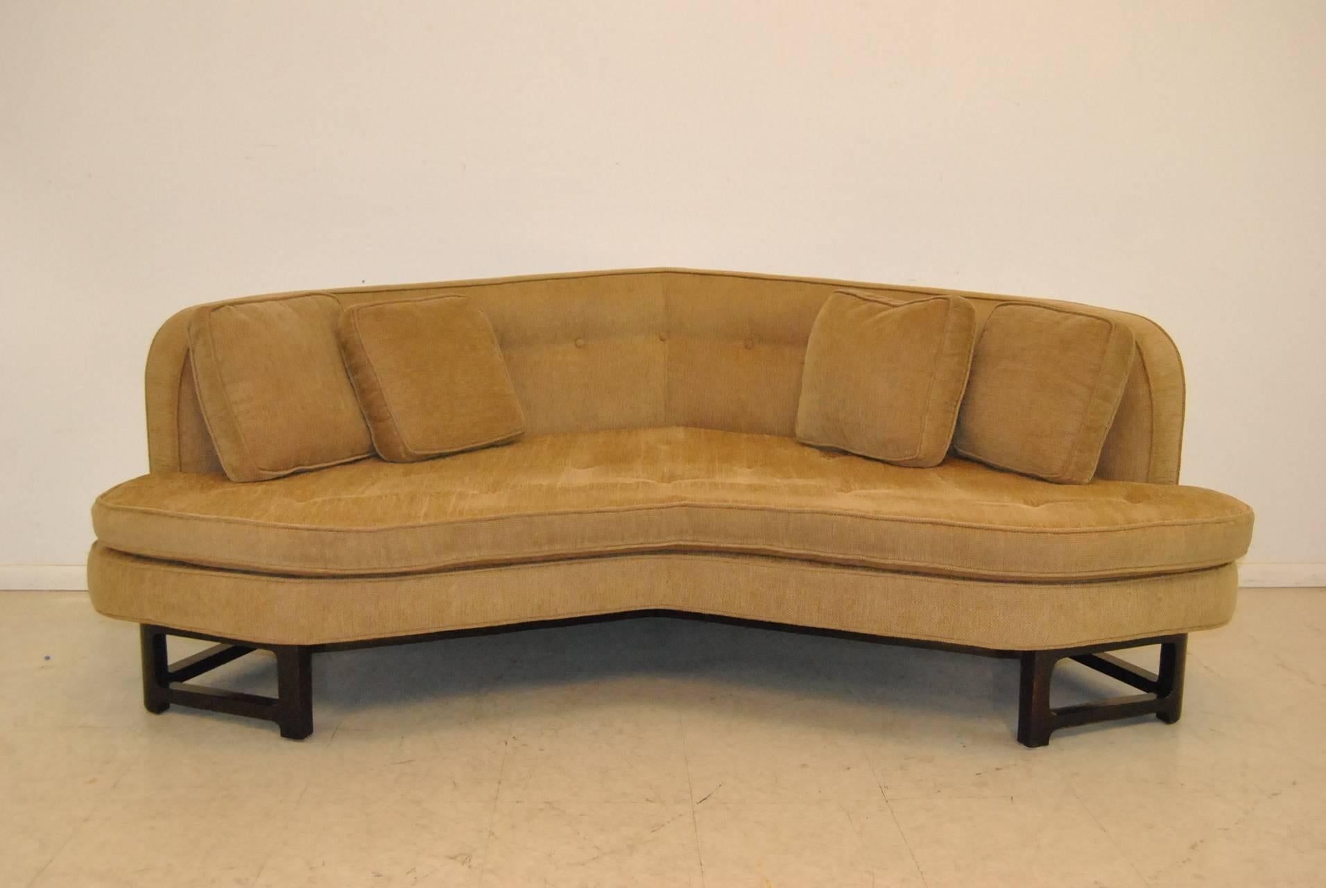 A beautiful Edward Wormley sofa for Dunbar from the Janus Collection, circa 1960s. This fantastic sofa is angled for comfortable conversation. It is attractive from every view. It sits on a very solid dark mahogany frame with a very pleasant beige