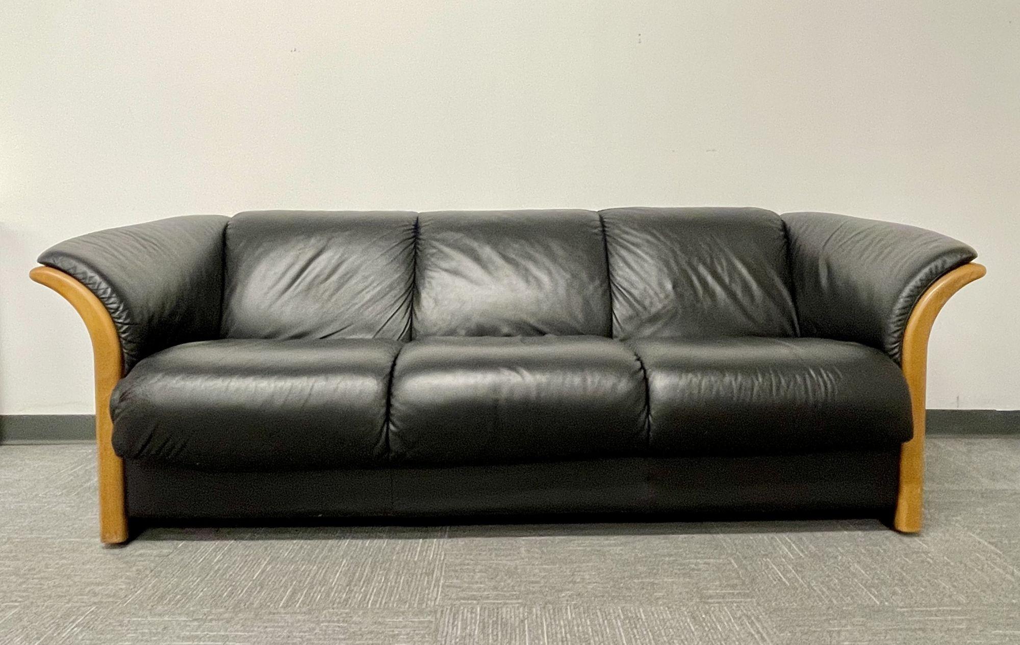 Mid-Century Modern sofa, couch, wood trim, black leather.
 
A finely detailed Mid-Century Modern Sofa. This three seater in a clean black leather having burl wood trimmed arms. 
 
Seat height: 17.5 in.
 
ESXA