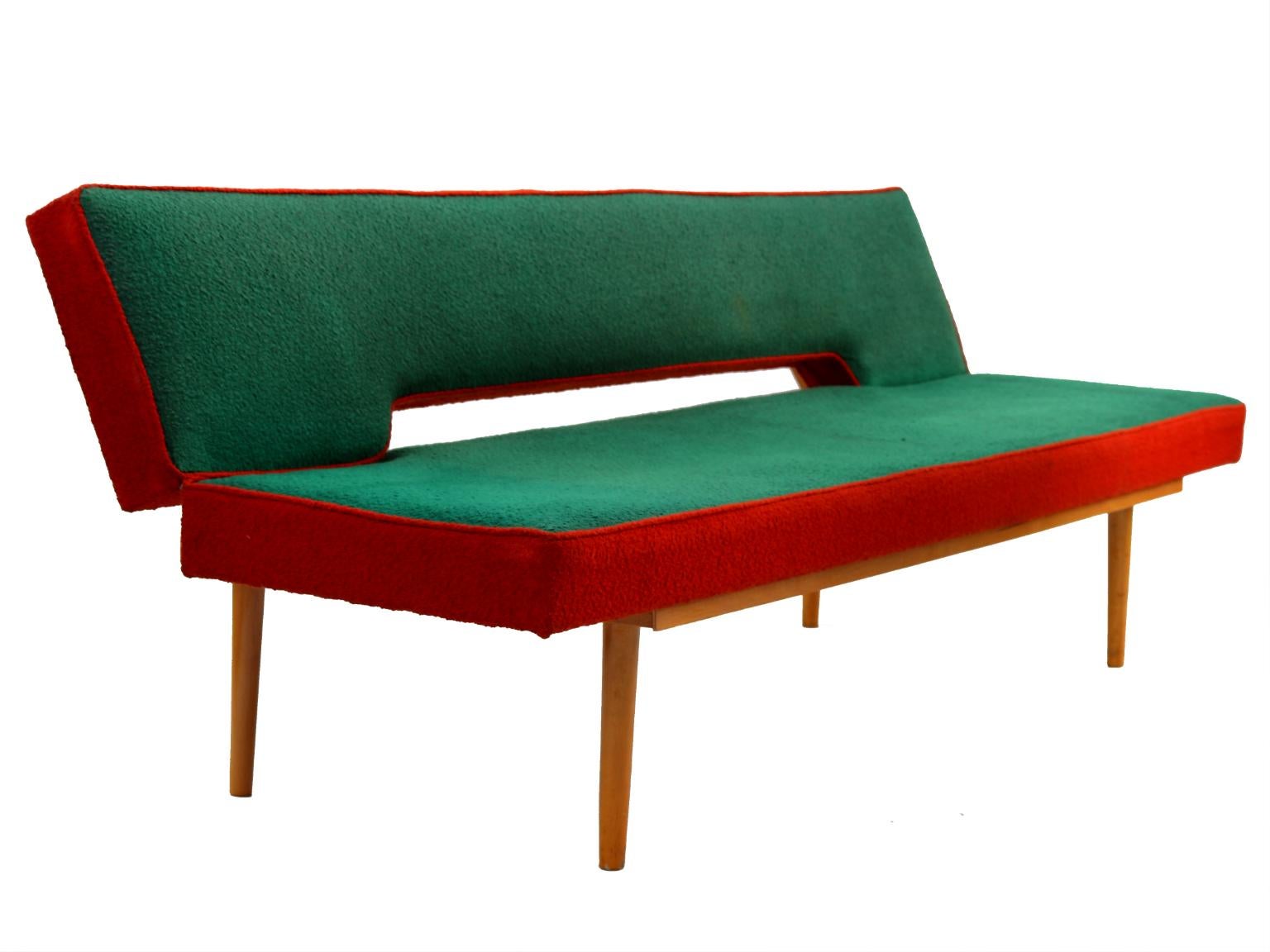 This sofa was designed by Miroslav Navratil in the 1960s fo Interier Praha Czechoslovakia. It features a beech frame with the original red and green fabric. It is easily folded out into a 90 cm wide bed,