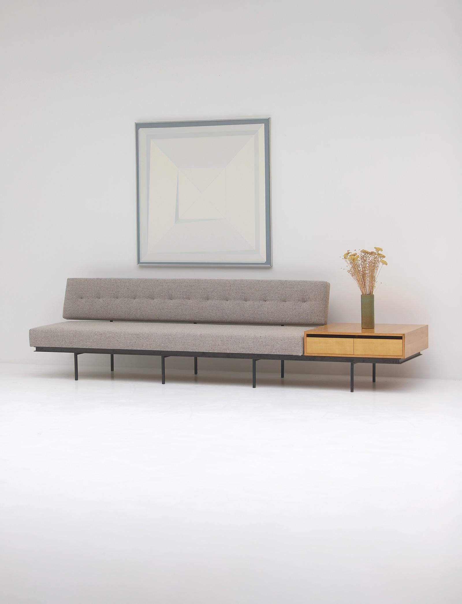 Mid-century sofa with wooden side table / end cabinet designed by Florence Knoll in the 1960s. The sofa has a black metal frame that supports a firm and well defined seat cushion back, which makes it very comfortable. The sofa has new foam and is
