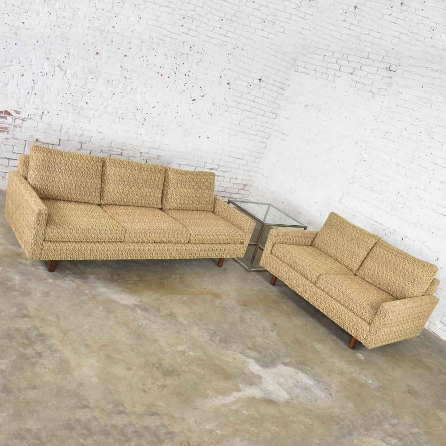 Handsome pair of Lawson style sofas, one three-cushion sofa and one two-cushion love seat, upholstered in a beautiful gold small geometric pattern. Styled after famed designer Harvey Probber with his signature cylindrical walnut feet. They are in