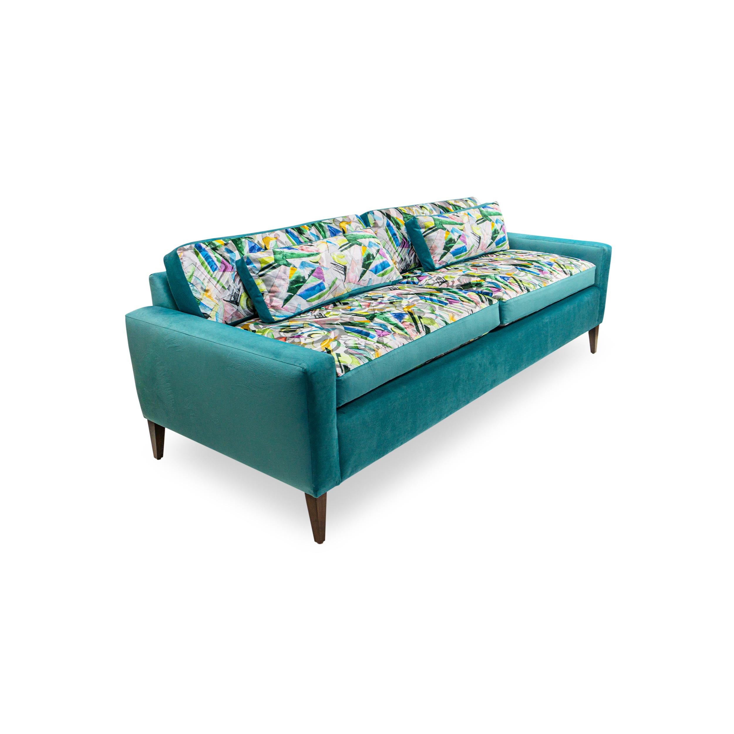 This luxurious Mid-century Modern designed Sofa is upholstered in a unique combination of deep turquoise and an exuberant abstract pattern from Osborne & Little's Palazzo velvet collection. Made to sink into the deep plush cushions and feel the