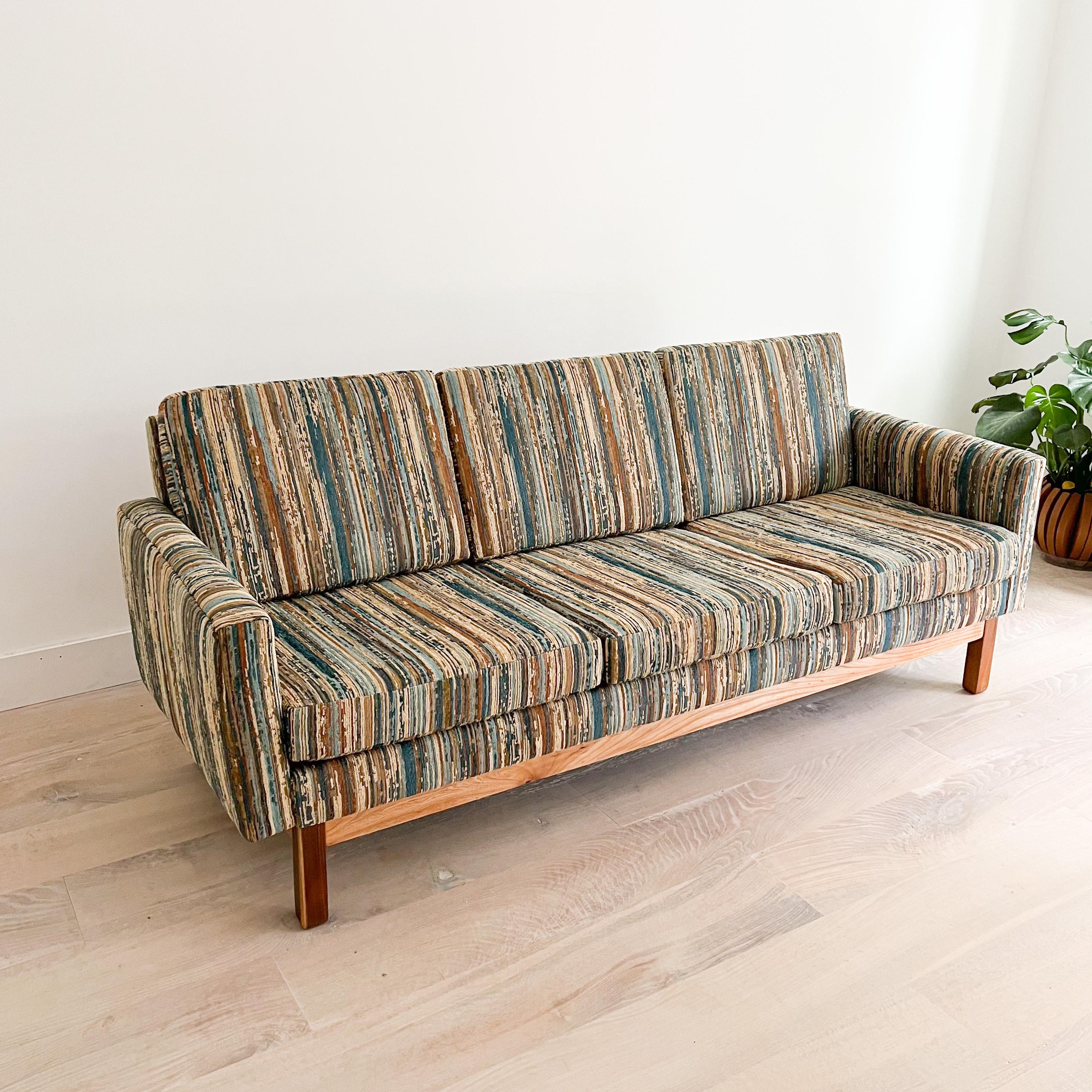 Mid-Century Modern three seater sofa. Refinished walnut and oak base. New foam and earth tone vintage style upholstery.
 