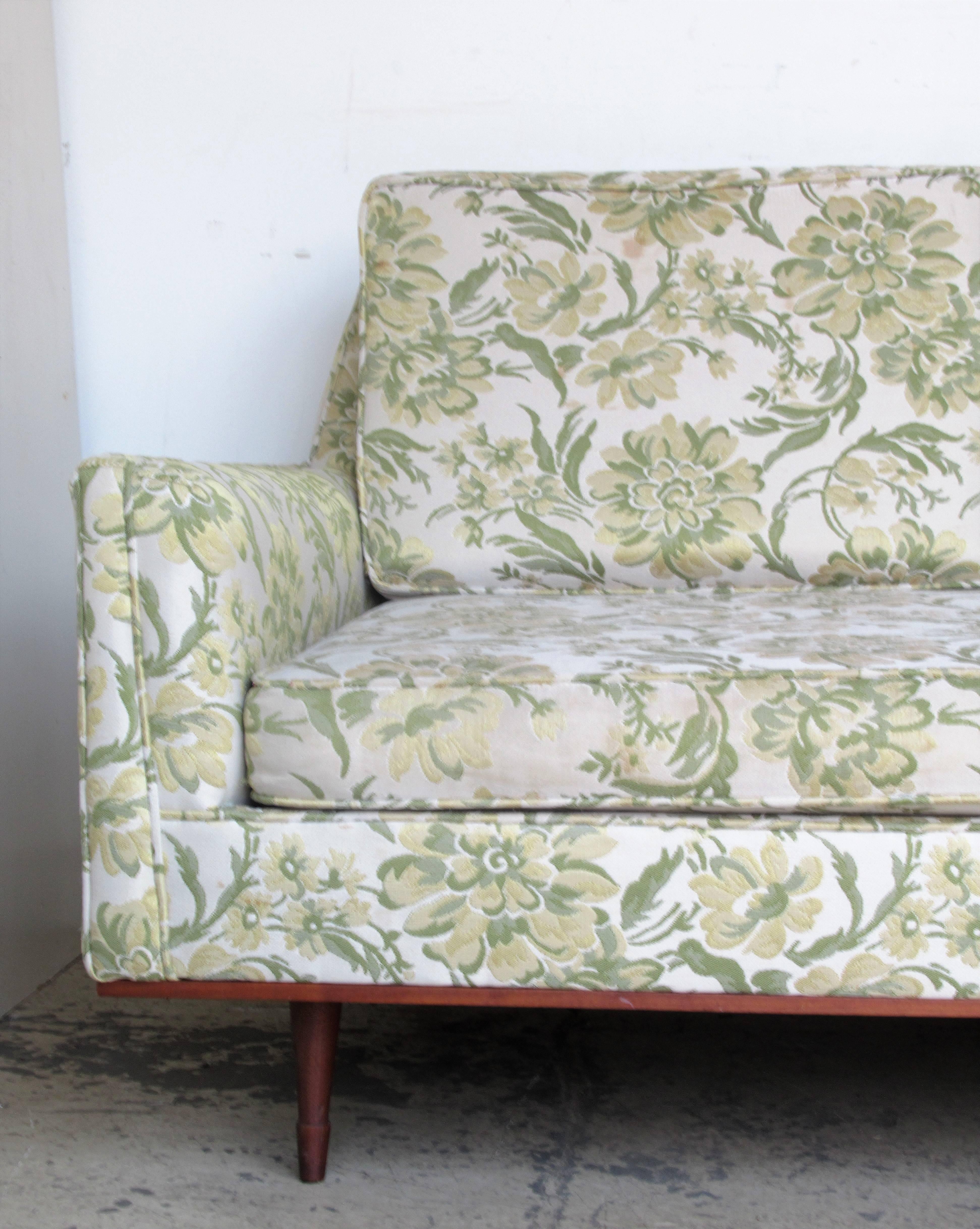 Great looking all original floral upholstered mid-20th century modernist sofa with a very elongated form ( nine feet long ) raised on six finely tapered unusual wood turned legs. Circa 1950 - 1960