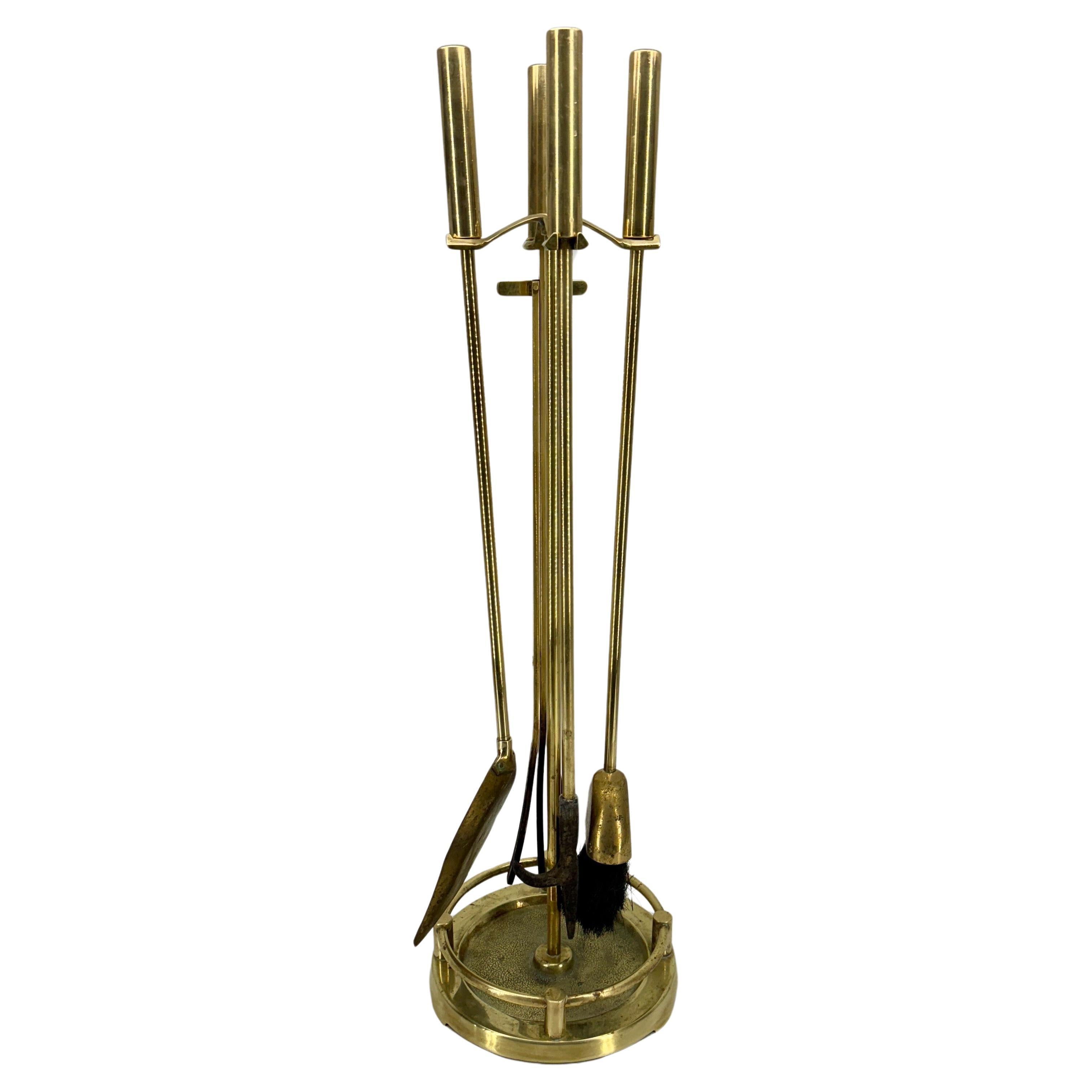 Set di quattro pezzi di strumenti per caminetto in ottone massiccio. Grande set classico d'epoca con una meravigliosa patina lucidata di recente. Questo set Mid-Century è elegante e funzionale sia in un ambiente moderno che tradizionale.
