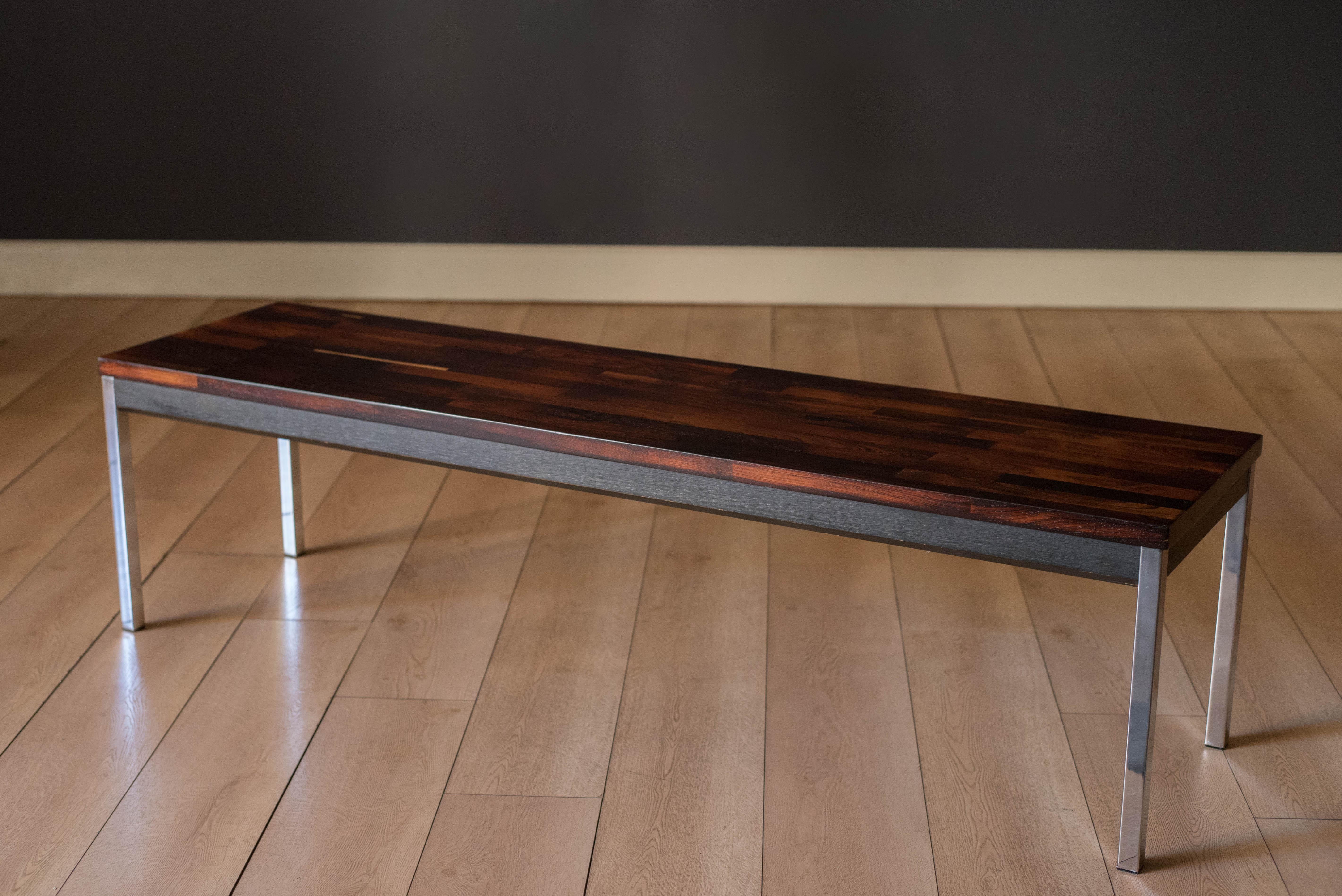 Mesa de centro vintage de palisandro macizo entarimado fabricada por Founders Furniture Company, hacia la década de 1970. Presenta un contraste de vetas de madera natural acentuadas con una base de ébano y robustas patas cromadas de apoyo. Esta
