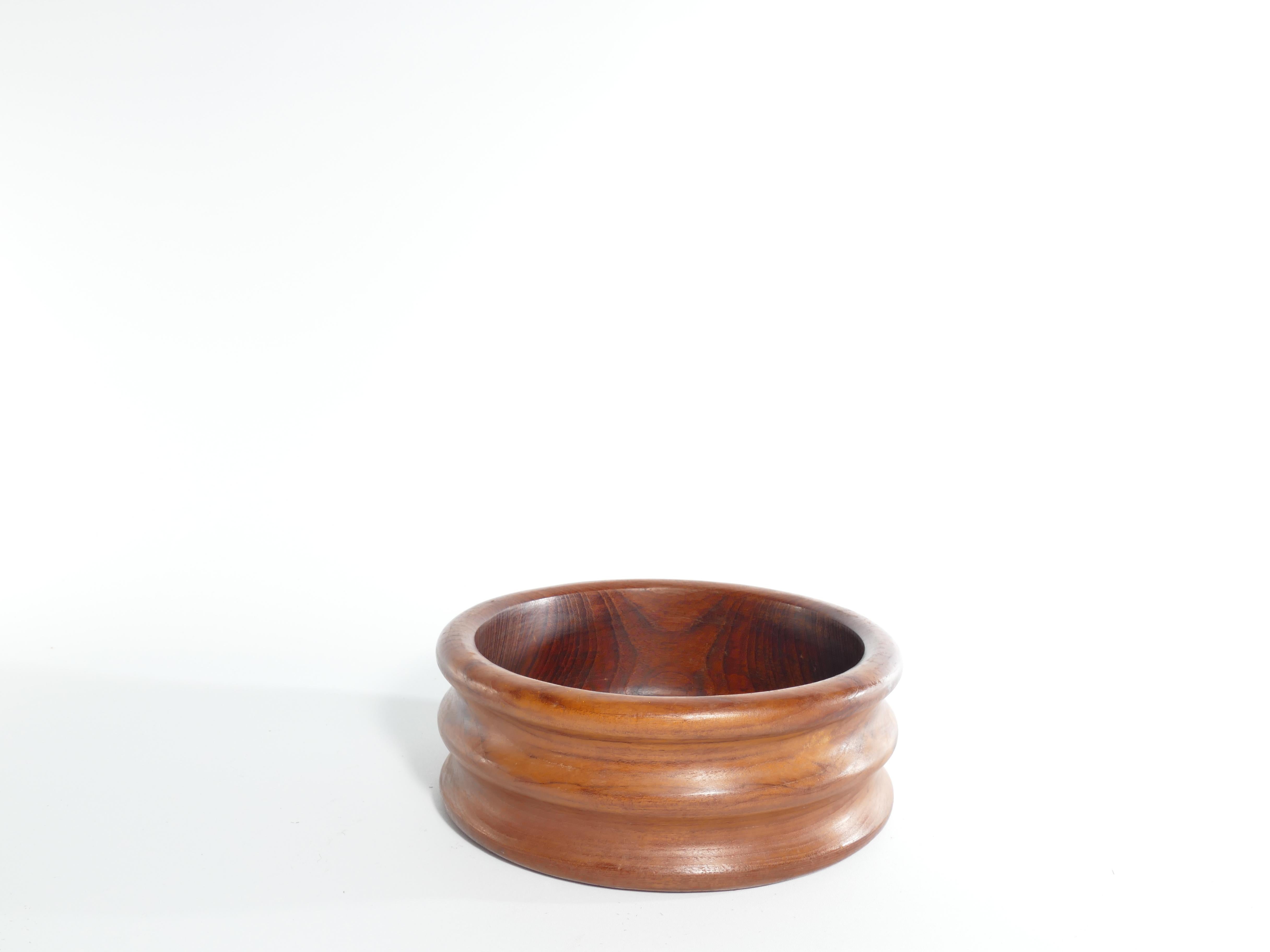 A very stylish mid-century modern teak wood bowl by Dolphin, Thailand. Whether displayed as a standalone art piece or used practically to hold fruits, decorative accents, or even as a conversation-starting centerpiece, this bowl is a true embodiment