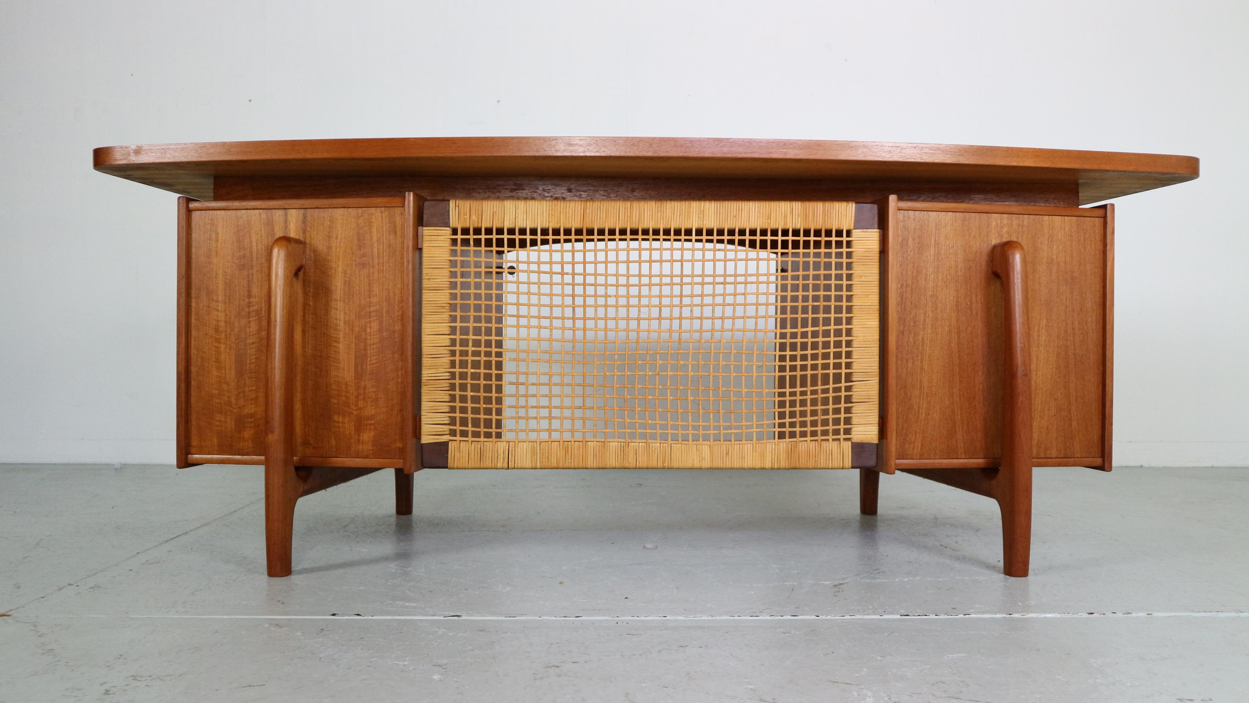 Mid- Century modern period extreordinary desk made in 1960's period, Denmark.

The desk contains solid teak wood and veneer. The backside is made if wicker rattan screen.
The table top has a floating feeling and its boomerang round shape.
It also