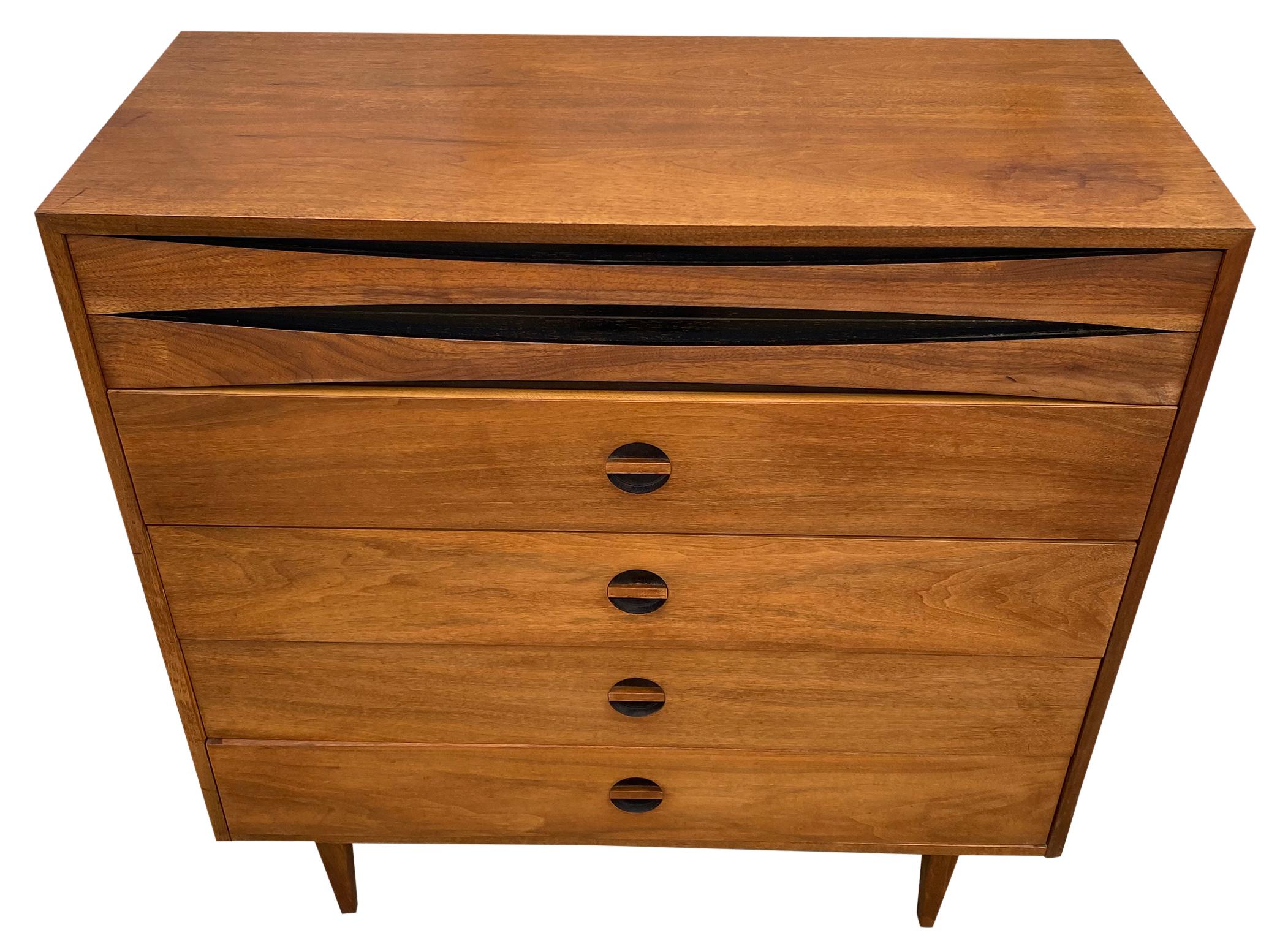 An exceptional Mid-Century Modern Arne Vodder style walnut 5 drawer tall dresser by West Michigan Furniture Co. The dresser features beautiful walnut wood grain with sculpted recessed drawer pulls. It offers ample storage, with 5 deep dovetailed
