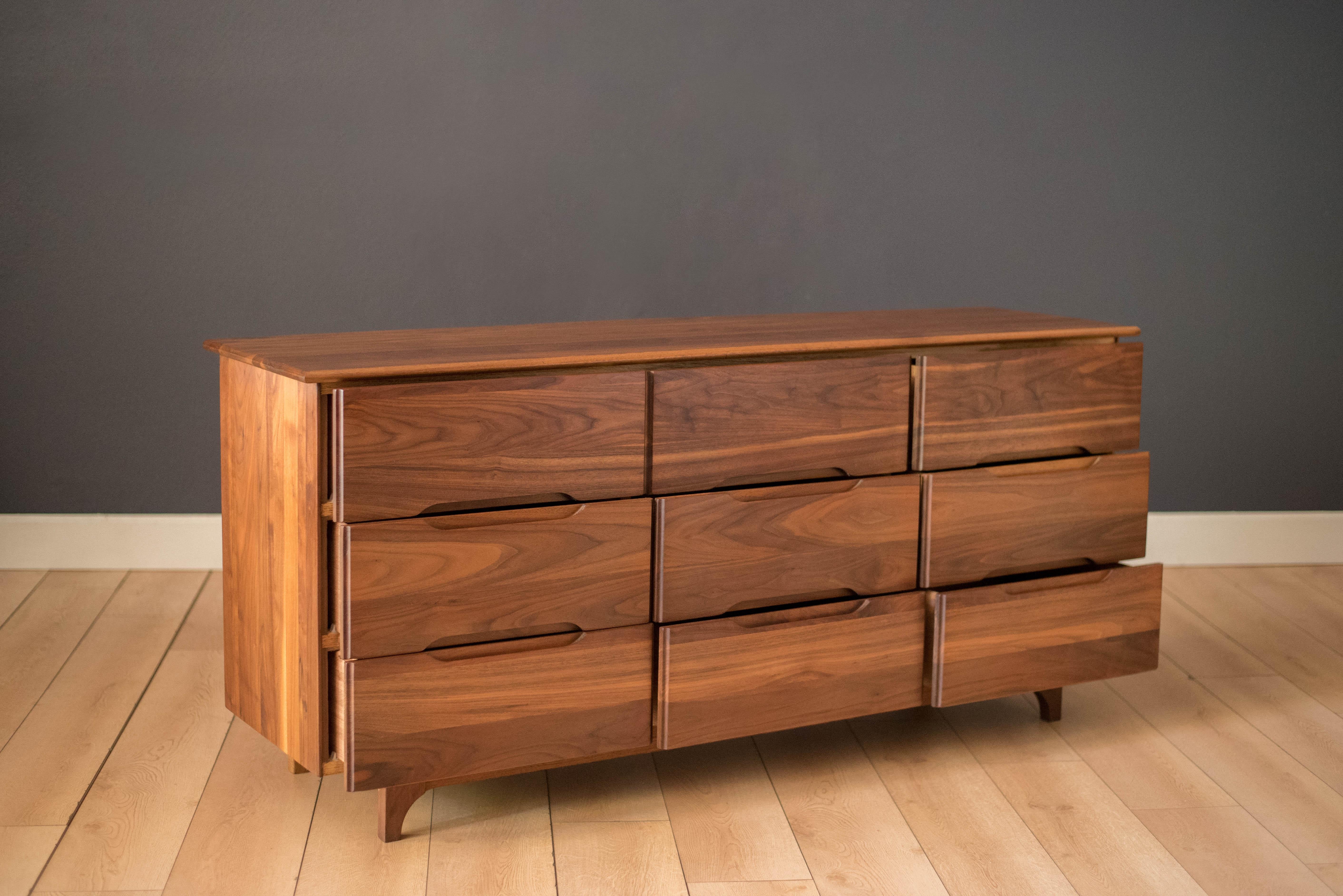Vintage dresser chest in solid planked walnut, circa 1960s. This piece features a stunning blend of walnut grains and includes nine storage drawers.