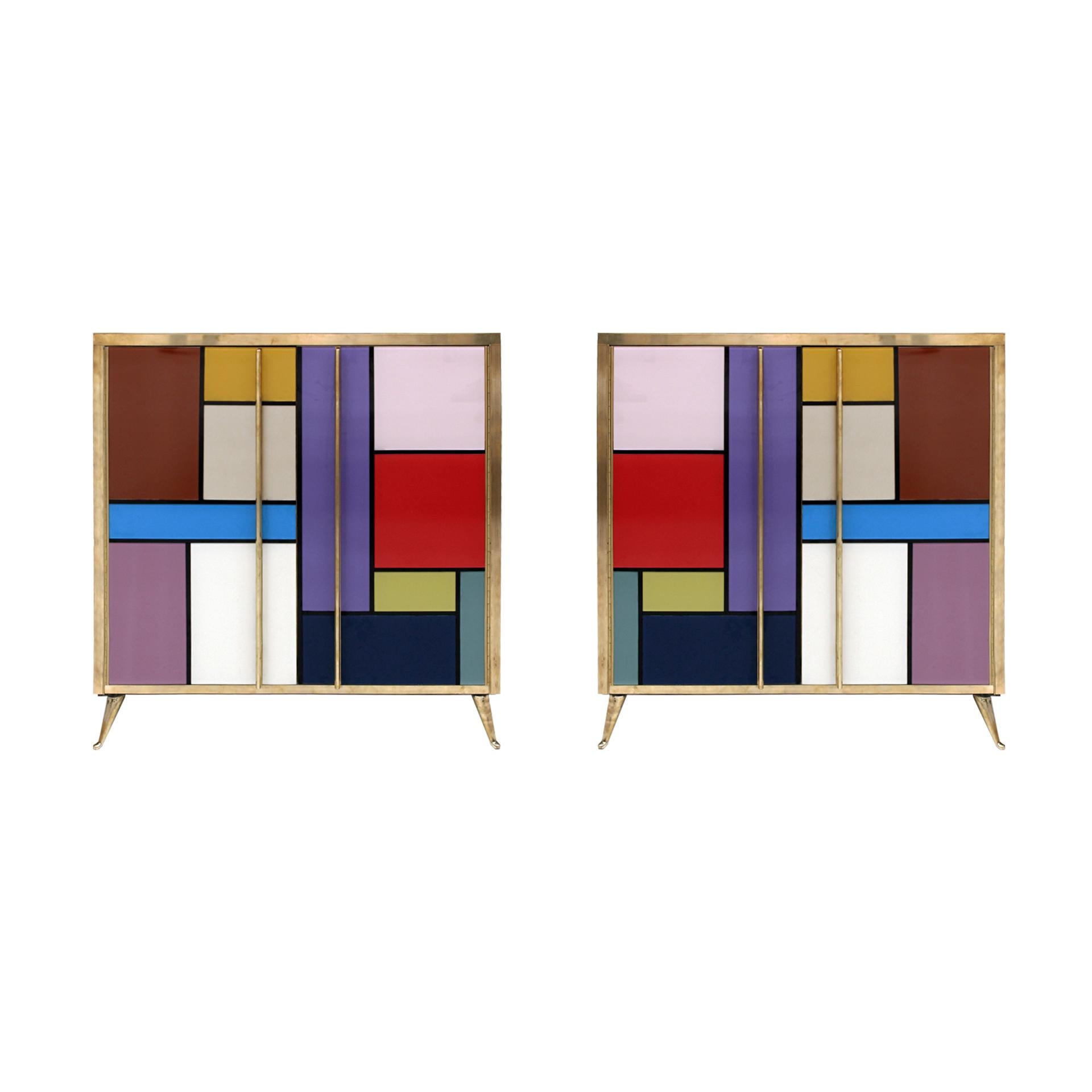 Paire de buffets composés de deux portes pliantes et d'une étagère à l'intérieur. Structure originale des années 1950 en bois massif et revêtue de verre coloré. Détails, poignées et pieds en laiton. 

Délai de production entre 5 et 6