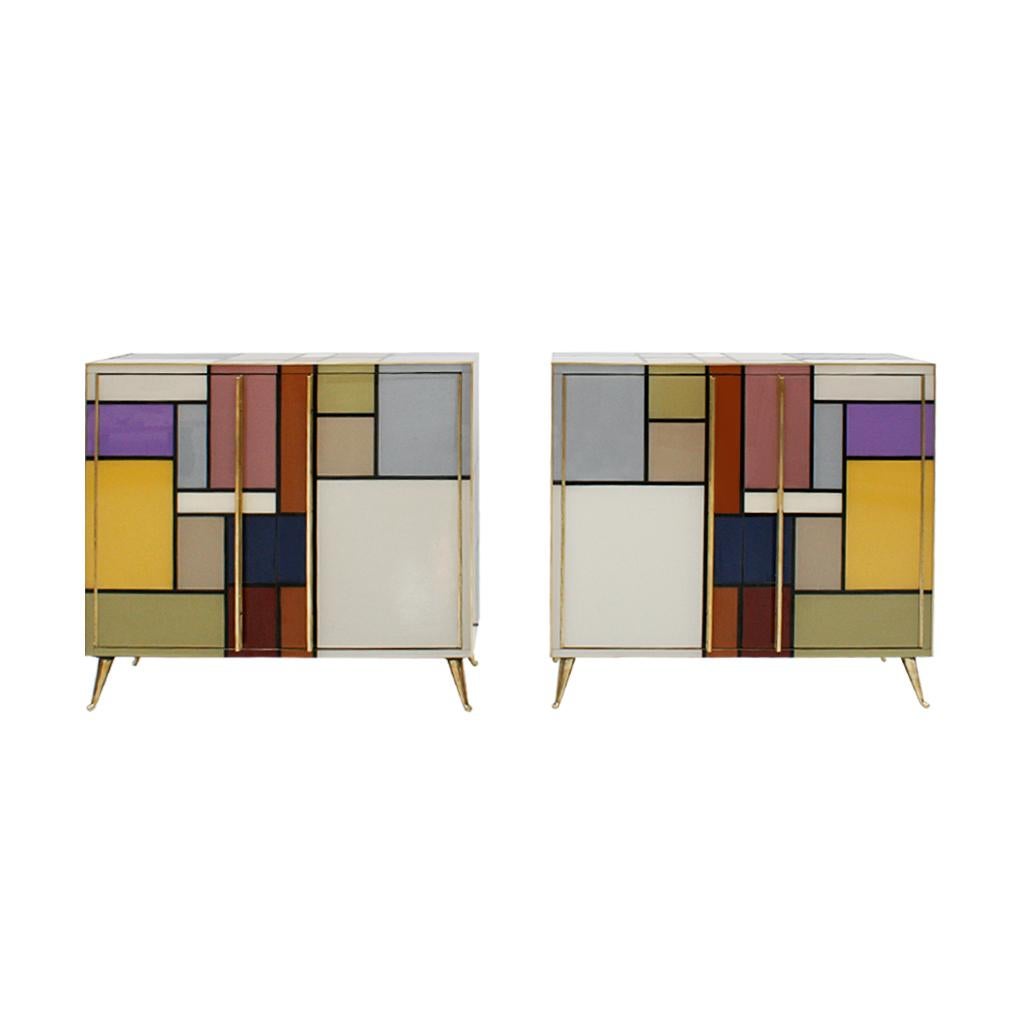 Pair of sideboards with two folding doors made of solid wood structure and coated with colored glass. Details and handles and legs made of brass.

Production can last between 5 and 6 weeks.

Every item LA Studio offers is checked by our team of 10