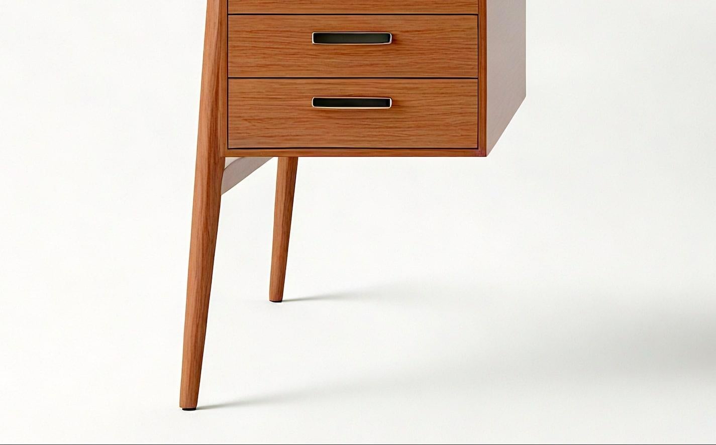 Eleva il tuo spazio di lavoro con questa straordinaria scrivania in stile Mid-Century Modern, meticolosamente realizzata a mano con legno massiccio di provenienza sostenibile. Progettato da Artisanal, questo pezzo unisce linee pulite, gambe