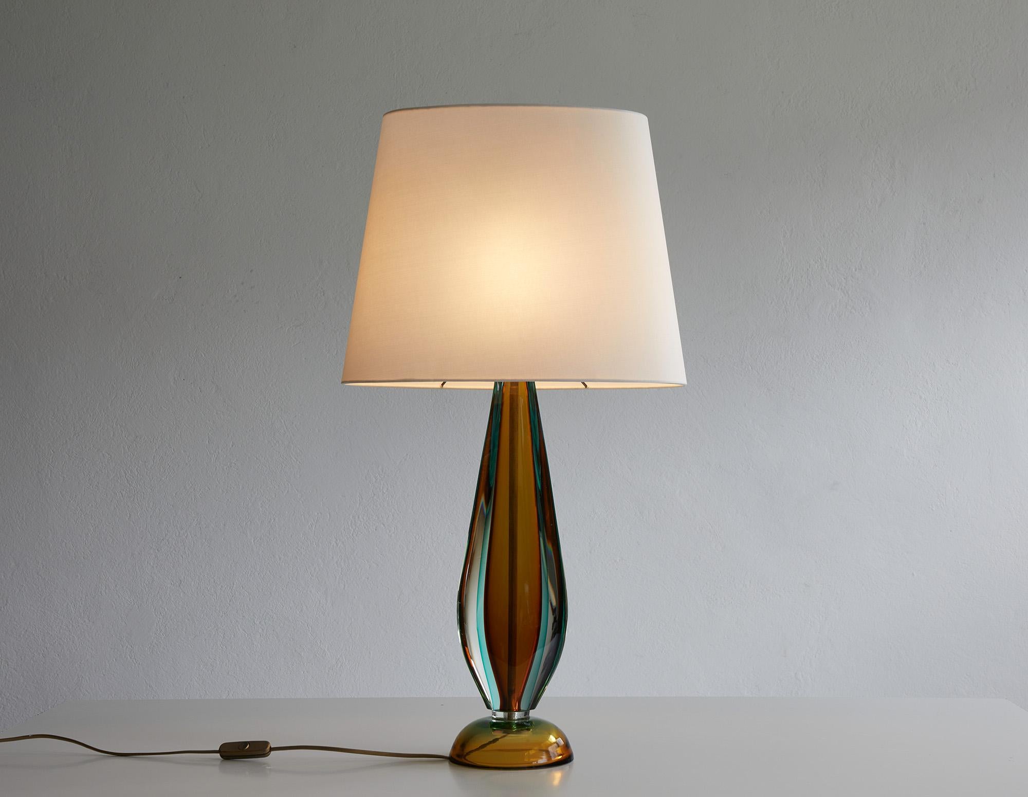 Elegant table lamp designed by Flavio Poli for Seguso Italy, 1960.

The structure, along with the rounded base, is crafted from multiple layers of amber and turquoise colored Murano glass in 