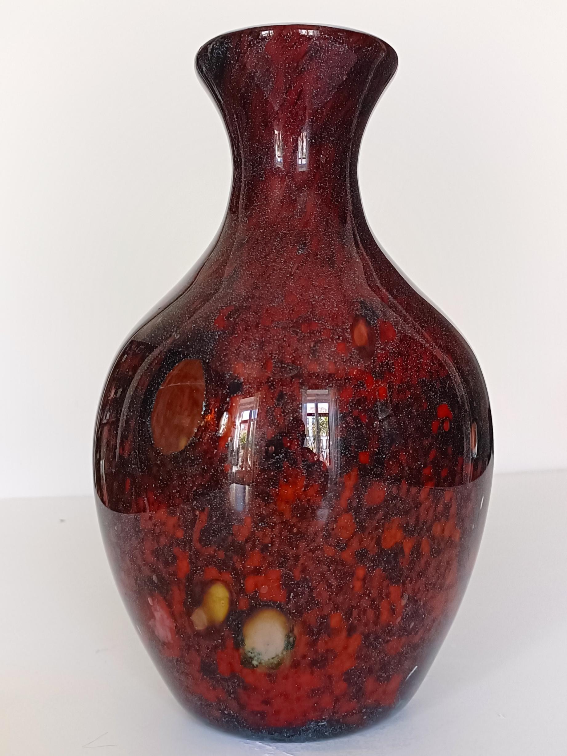 Step into the timeless elegance of Mid-Century Modern Murano glass with this exquisite hand-blown vase, a gorgeous piece that blends artistry and craftsmanship. 

This outstandingly beautiful piece features an intricate pattern of red and burgundy