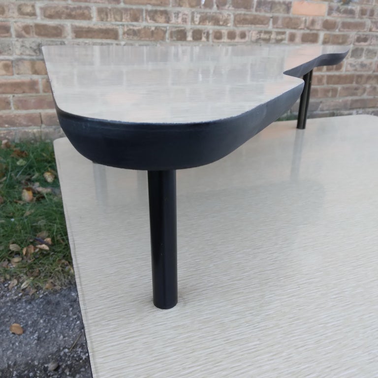 This Mid-Century Modern accent table has a cool Space Age feel with her geometric shape and laminate and metal combination. Retro, vanilla-toned laminate provides a durable and authentically Mid-Century table top. Her two-tier formation allows for