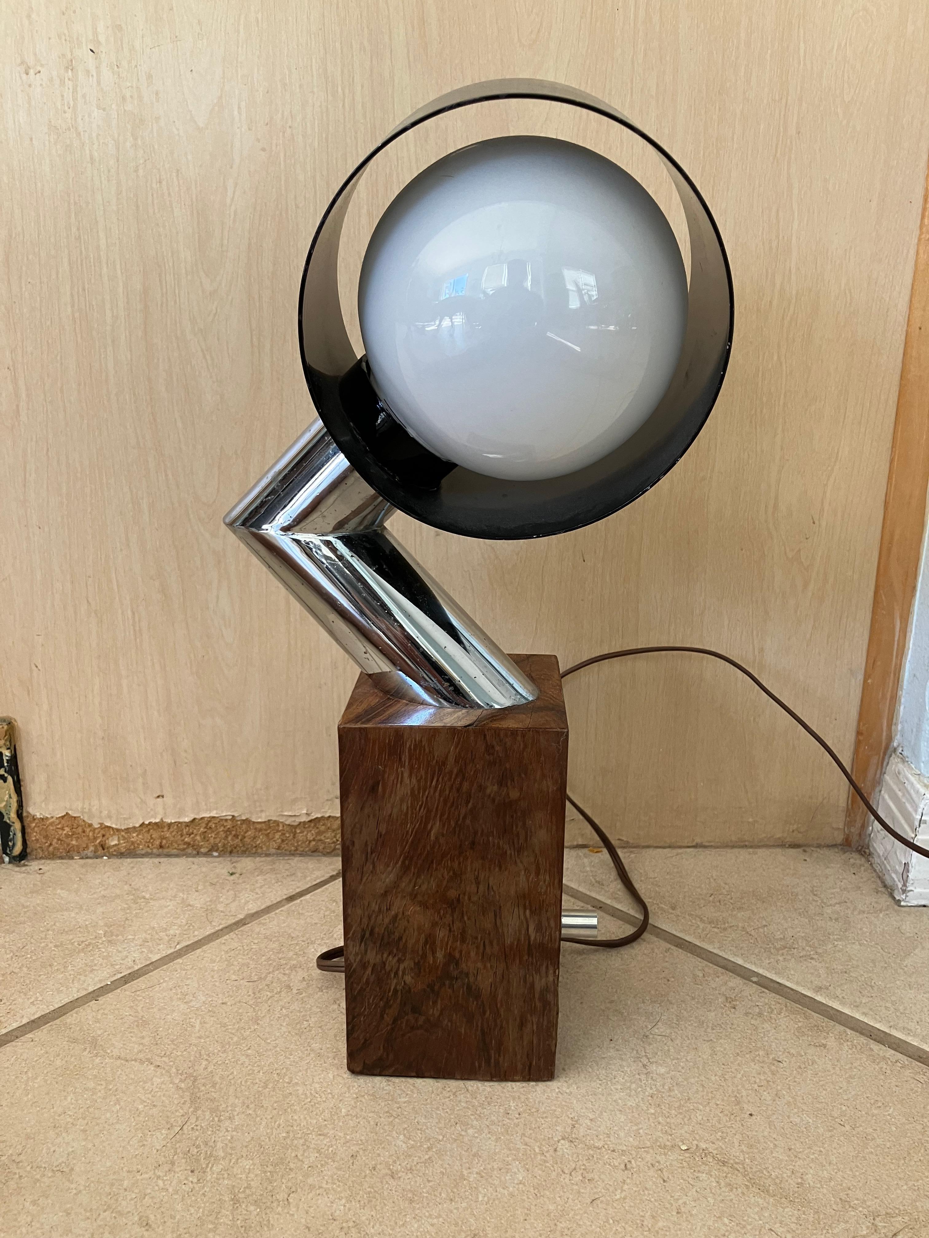 Fabulous really cool mid-century modern space age lamp. It is made of chrome and a solid piece of what looks like Burlwood holding it up. I could not find another example of this lamp. It is very good condition and has a dimmer on the switch.