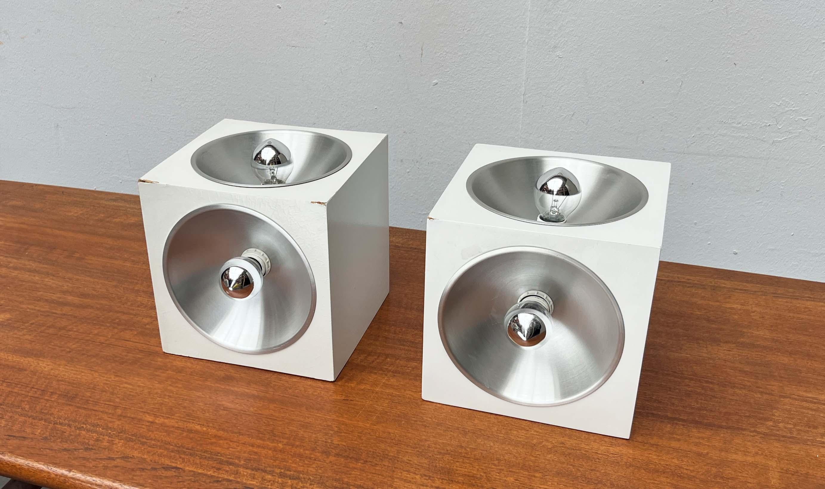 Very rare Space Age table lamps from the renowned manufacturer Temde, based on a design by Eva Renée Nele from the 1960s.

Functional light sources with an object-like character. The lamp body is formed by a white-coated cube. Parabolic aluminum