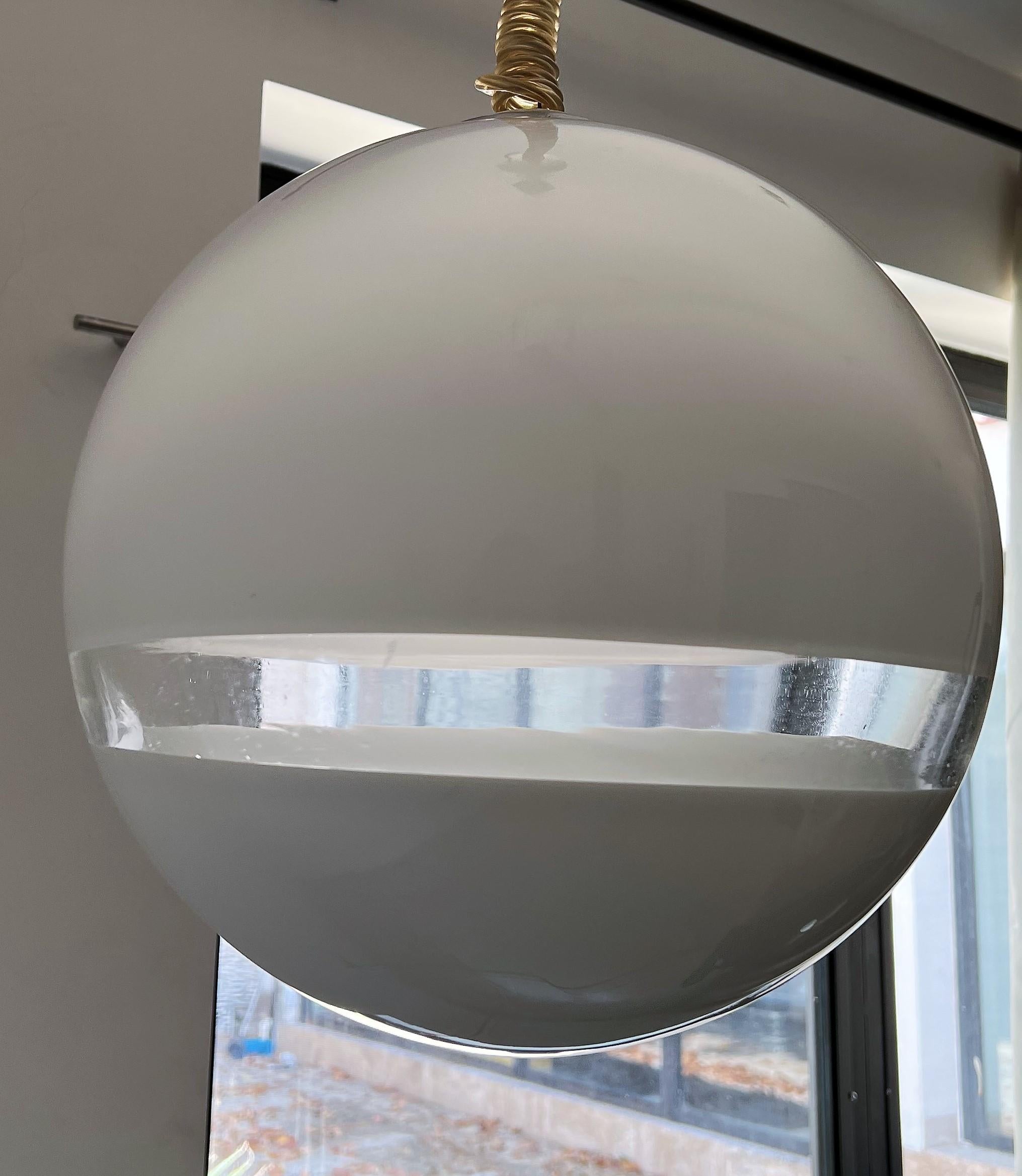 Suspension de l'ère spatiale fabriquée en verre de Murano soufflé à la bouche, blanc et transparent, signée par Leucos et conçue par Roberto Pamio, vers 1970.
L'état est excellent, le baldaquin est en plastique et porte également la marque Leucos,