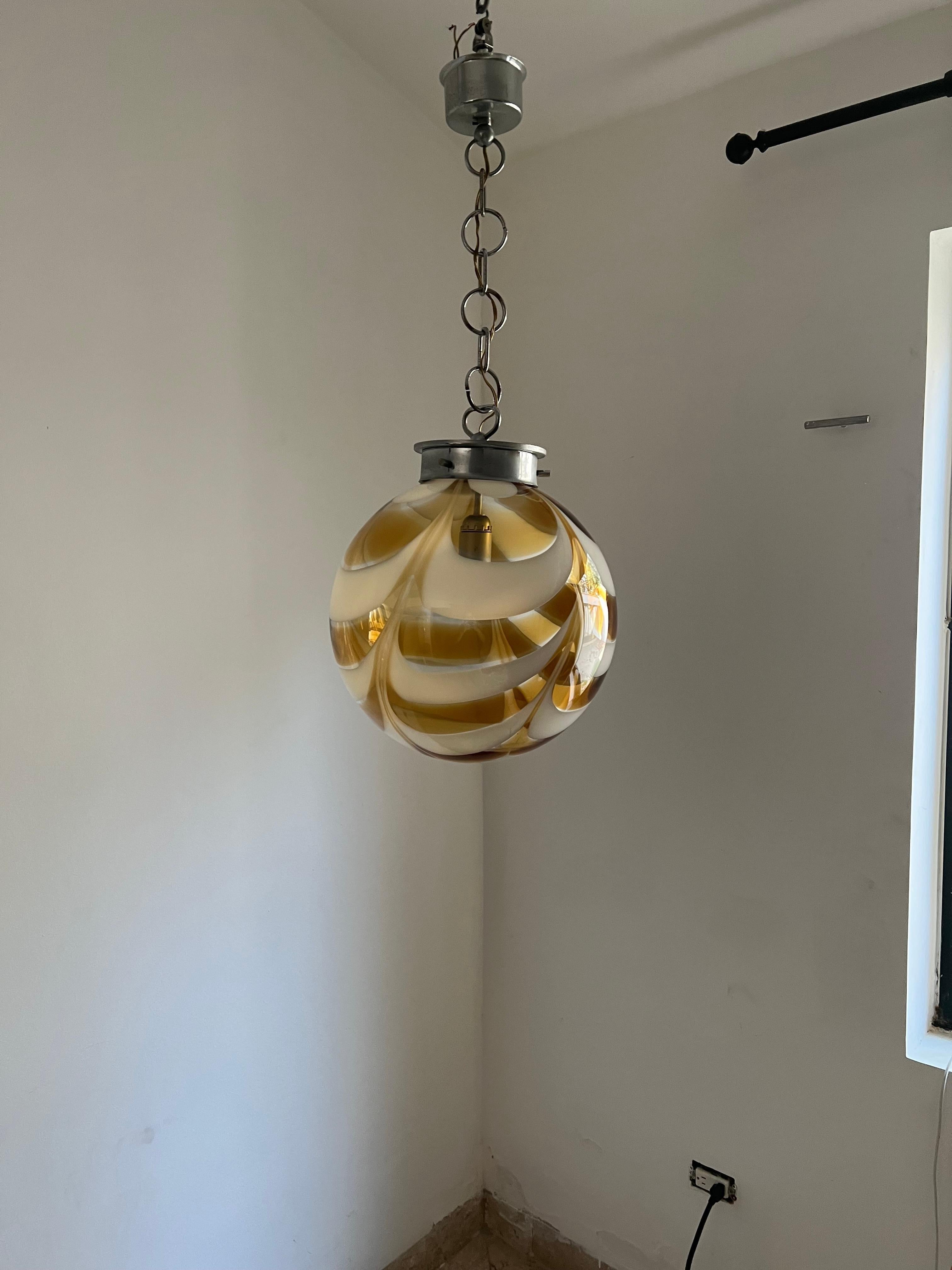 Space Age pendant light manufactured in white and orange swirled hand blown Murano glass, attributed to Mazzega, circa 1970.
Measures: Diameter is cm.
Height is 80 cm but can be easily adjusted to Measure.