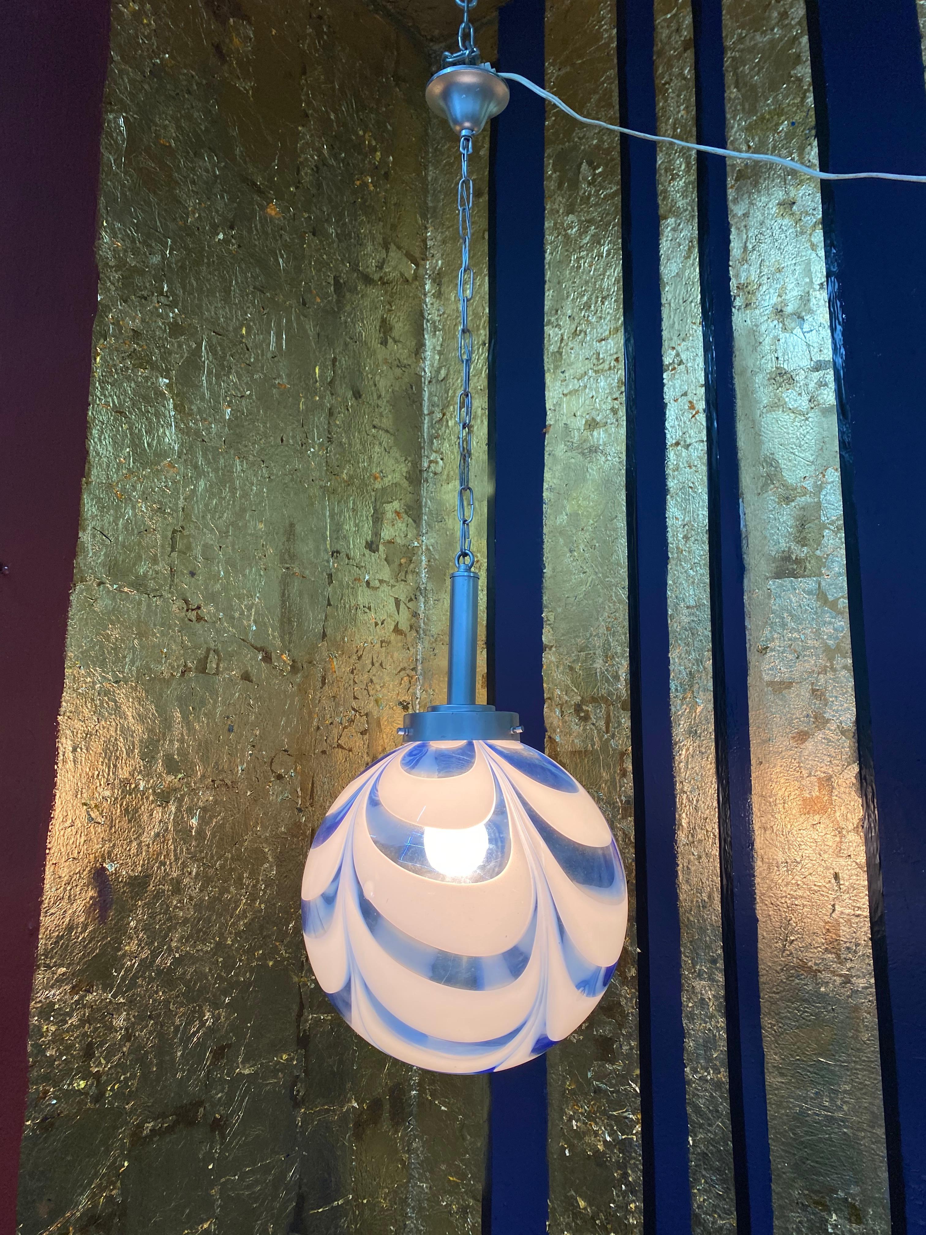 Space Age pendant light manufactured in clear, white and blue swirled hand blown Murano glass, attributed to Mazzega, circa 1970.
Measures: Diameter is 29 cm.
Height is 110 cm but can be easily adjusted to measure.
   