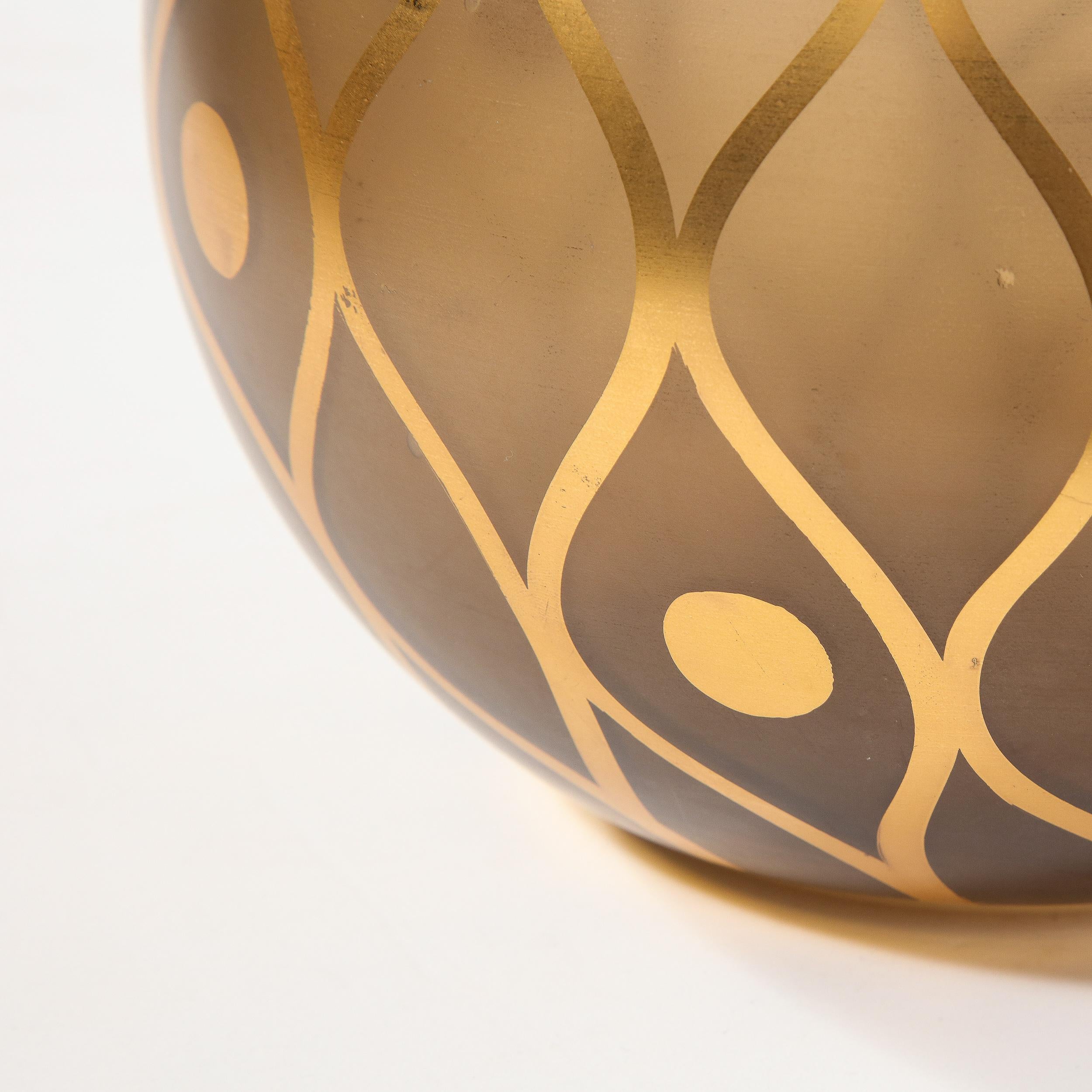 This sophisticated Mid-Century Modern vase was realized in France, circa 1960. It offers a spherical glass body in a rich smoked bronze hue. The exterior of the piece is adorned with curvilinear detailing- undulating lines that meet to create